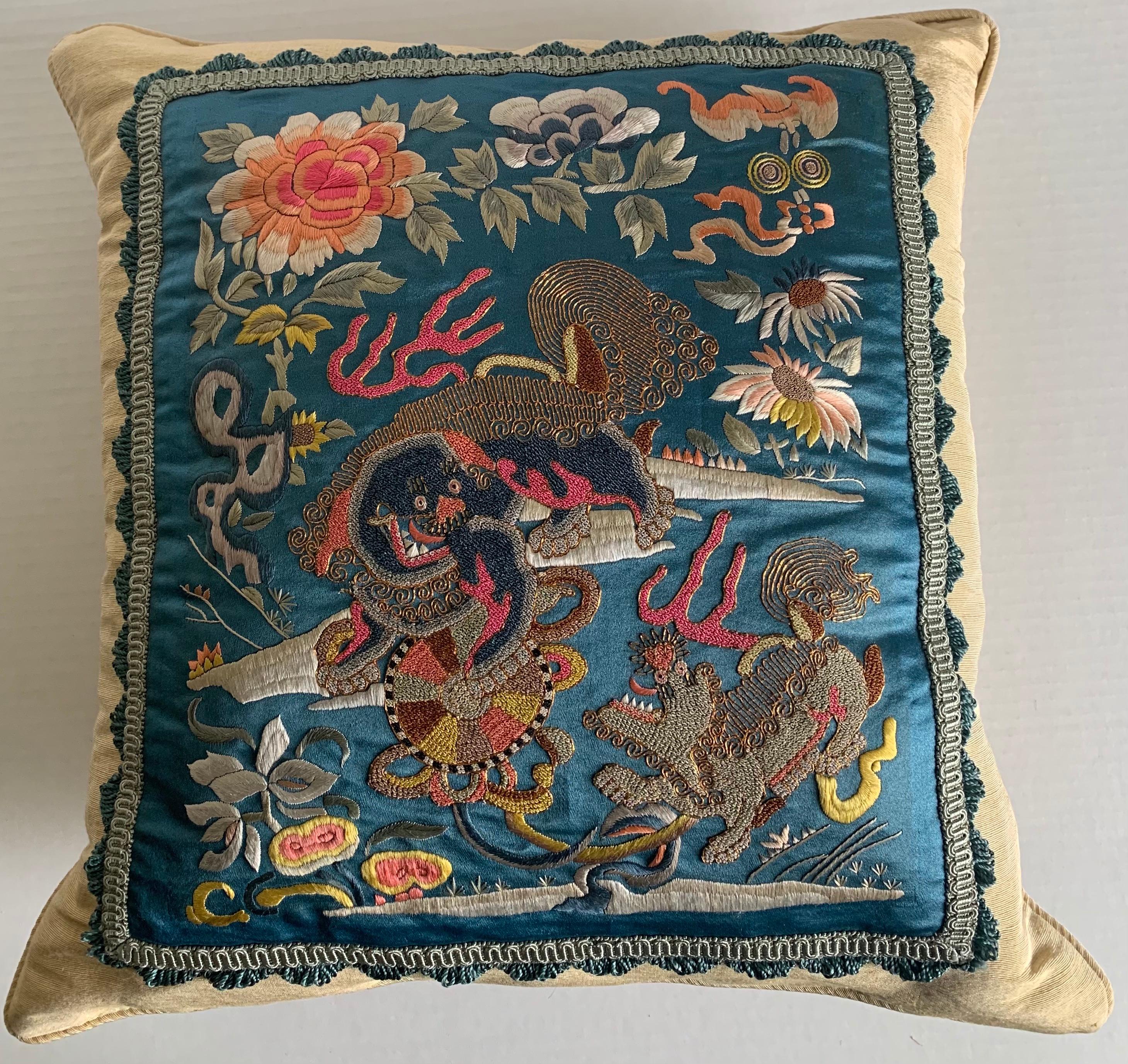 Antique Chinese embroidered textile made into a custom pillow. Antique blue woven satin silk textile featuring playful foo dog motif. 
Pillow is made of Claremont champagne silk with brushed fringe and gimp trim. 
Sewn shut style, pillow is 100%