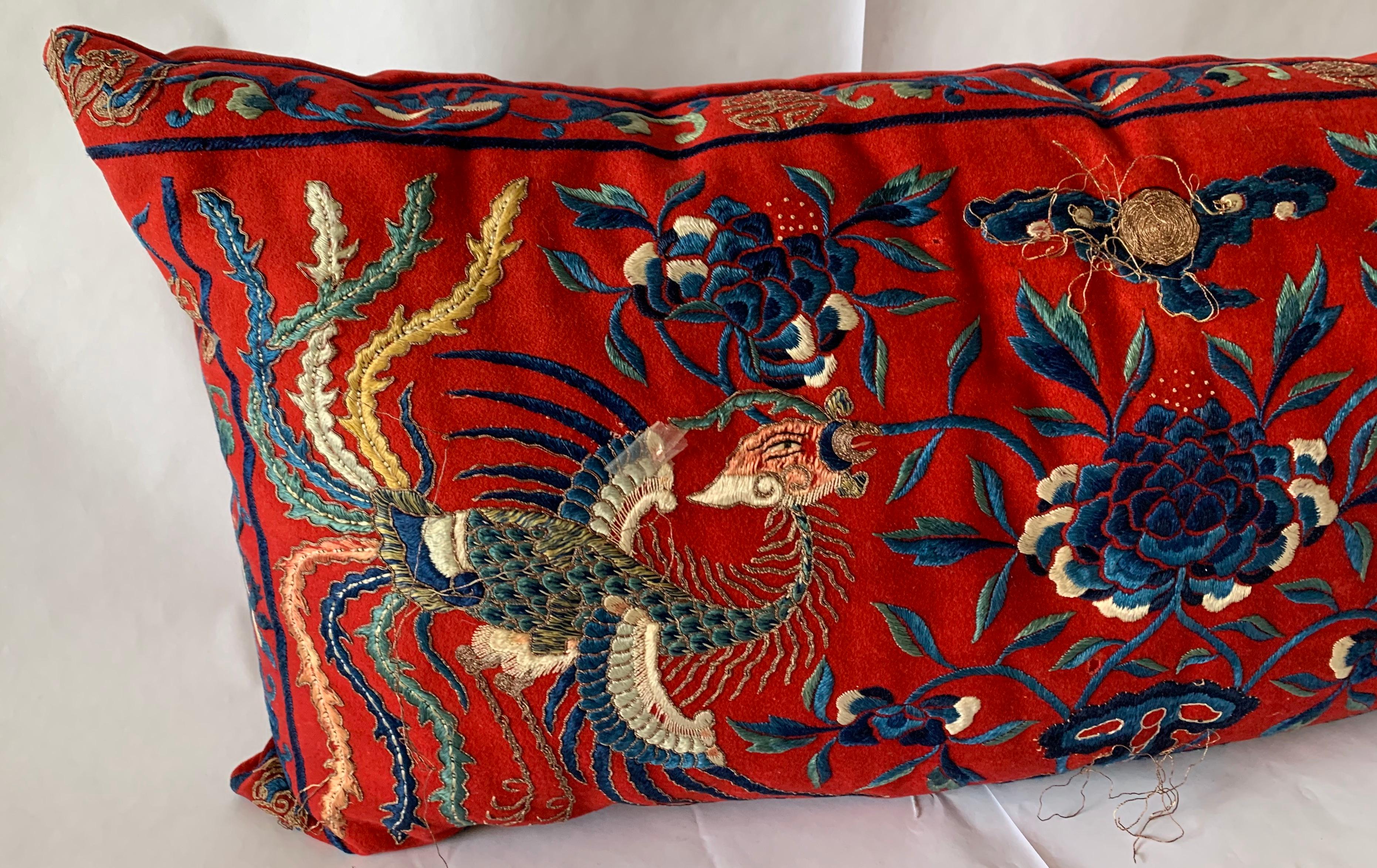 Antique Chinese embroidered textile made into a custom lumbar pillow. Red wool embroidered textile with gold couching (threading) and backed in red velvet.