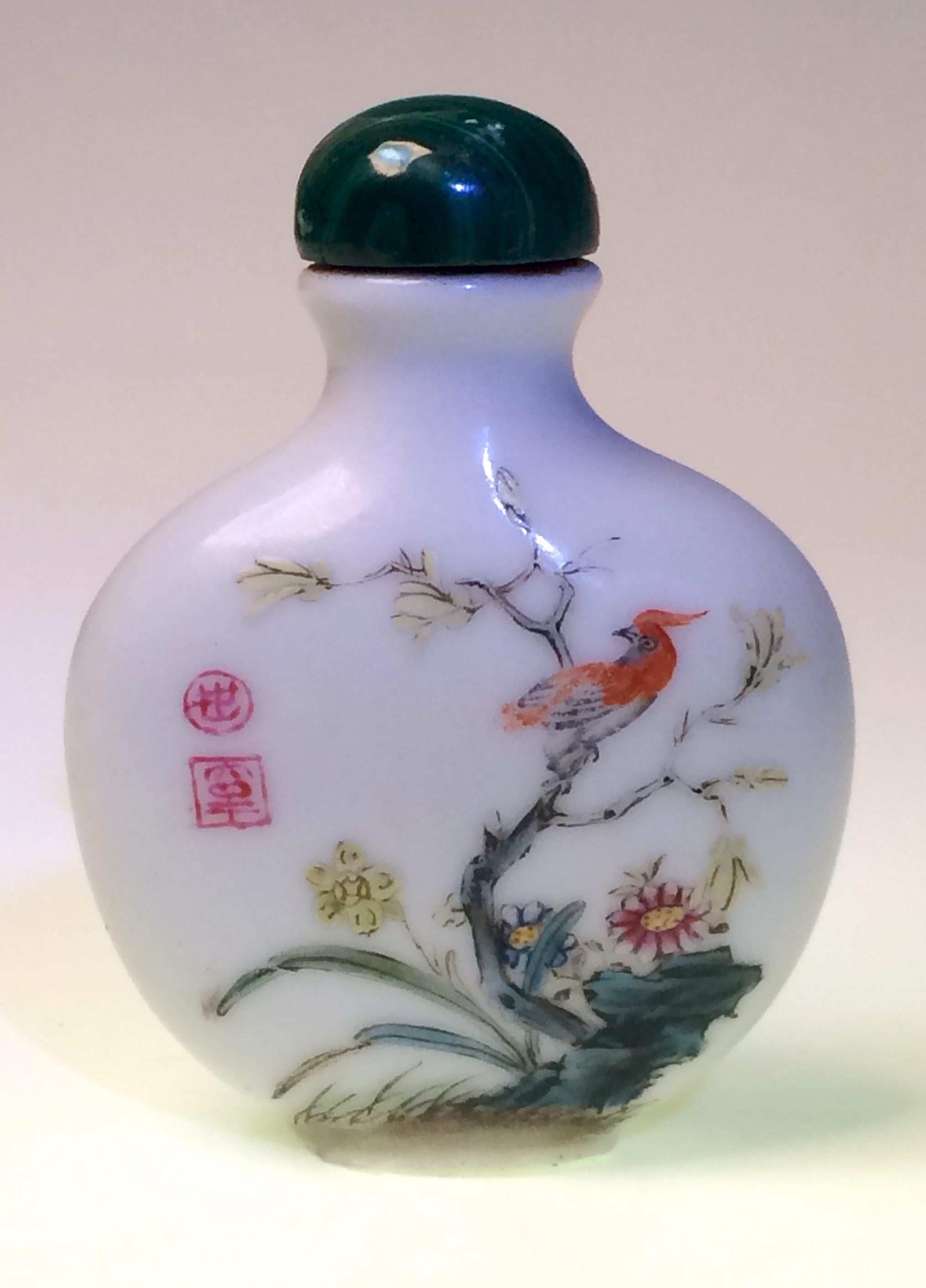 Antique Chinese enameled porcelain snuff bottle, flattened circular form with raised neck everted lip, flat gilt mouth rim, concave base, one side painted with iris, chrysanthemum, two butterflies and two unidentified red seals, the opposing side