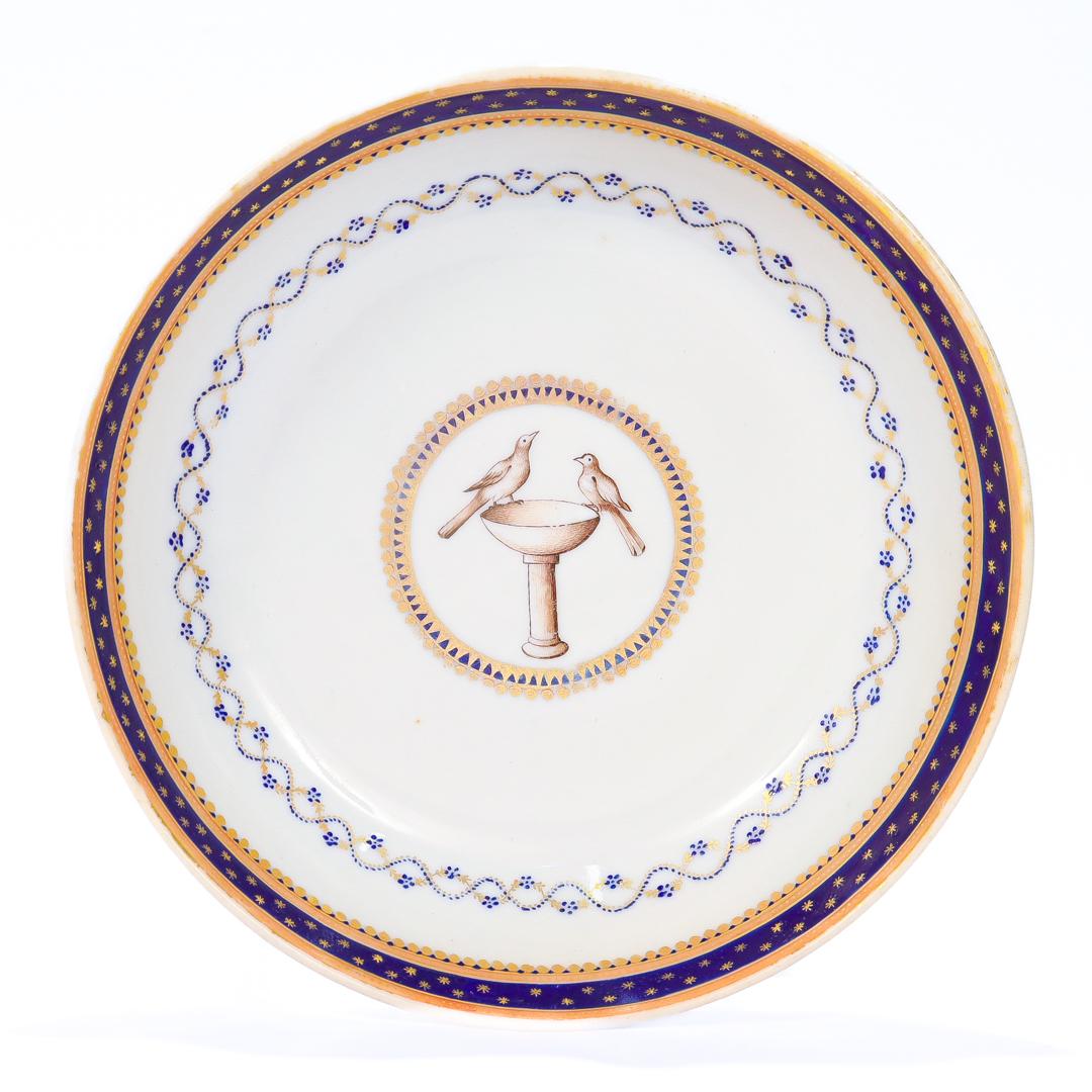 A fine late 18th or early 19th Century Chinese export armorial porcelain saucer.

With a white ground and cobalt blue and gilt geometric designs.

The center bears an armorial crest with two doves atop a birdbath that bear a resemblance to the