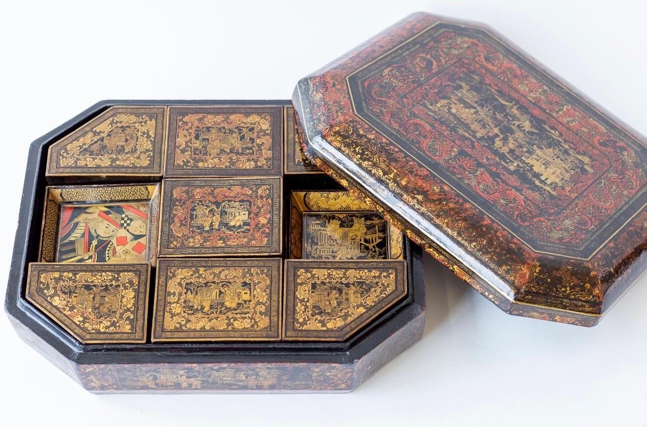 Boîte de jeu chinoise en laque du XIXe siècle, probablement de la dynastie Qing.

Il est en bois laqué, décoré à l'extérieur en noir, rouge et or avec des motifs de pavillons et de personnages, entourés de bordures détaillées.

Il présente des