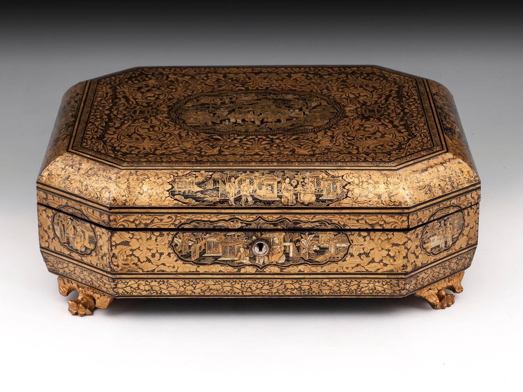 Chinese Export lacquer box, octagonal in shape with rolled top, hinged lid, standing on four winged dragon claw feet. The box is extensively decorated in gilt with black lacquer: with various scenes of small Chinese figures in pavilion gardens, the