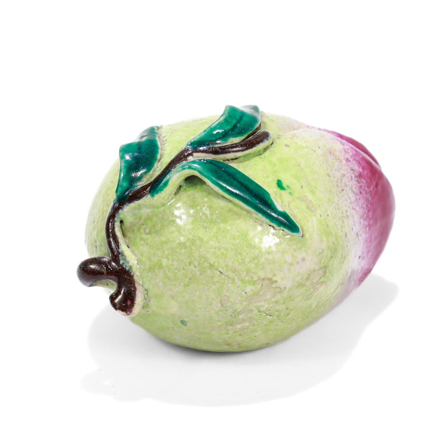 A fine figural altar fruit model.

In Chinese Export porcelain.

Modeled as an unripened peach or mango.

With green, yellow, and dark pink glazes.

A fine addition to any collection!

Date:
20th Century

Overall Condition:
It is in overall good,