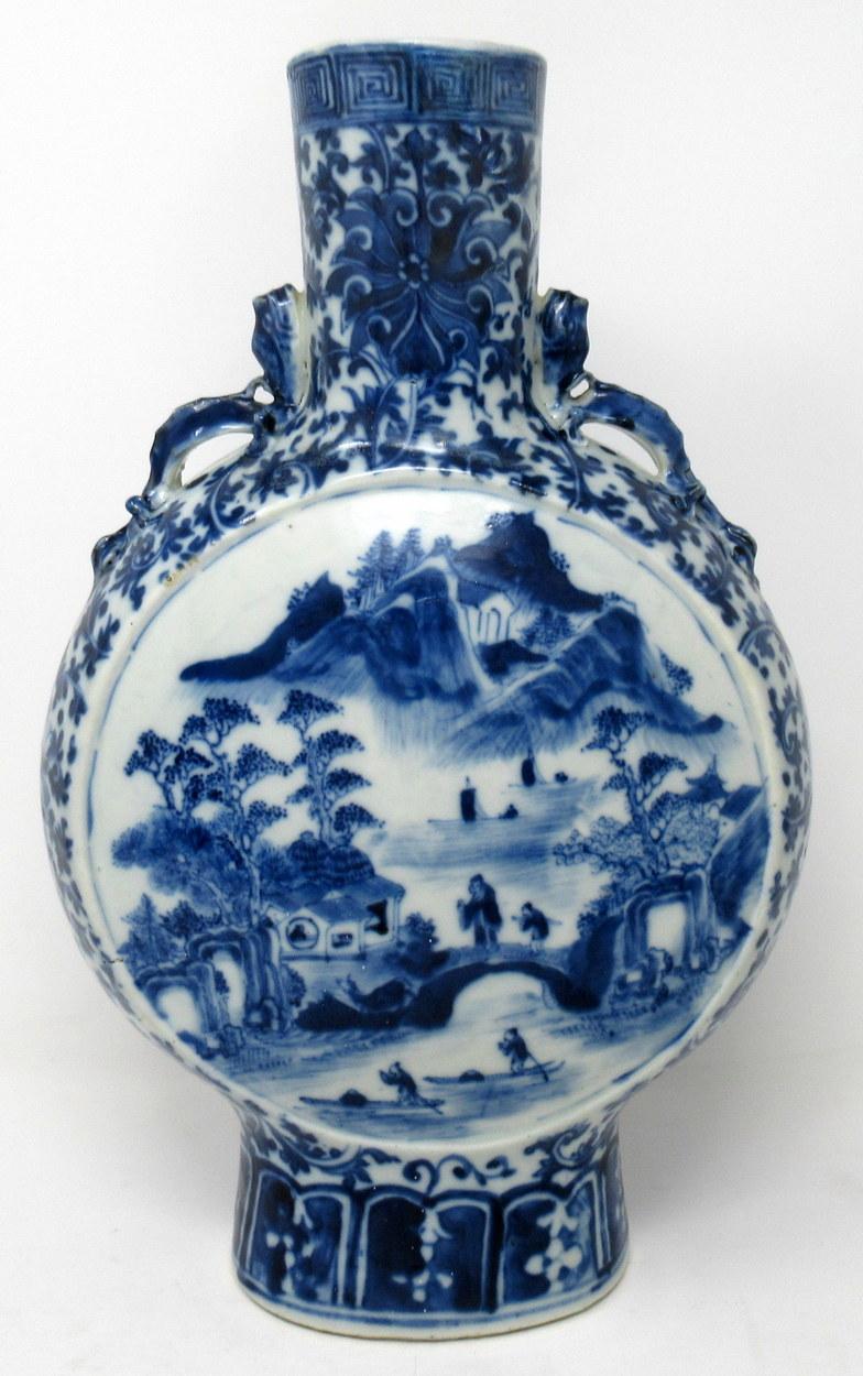 An unusually large and quite rare Chinese export porcelain twin handle moon flask of traditional discodial form, with cylindrical neck and stylised handles applied to the lower neck modelled as Dragons. 

Hand decorated in underglaze blue on white
