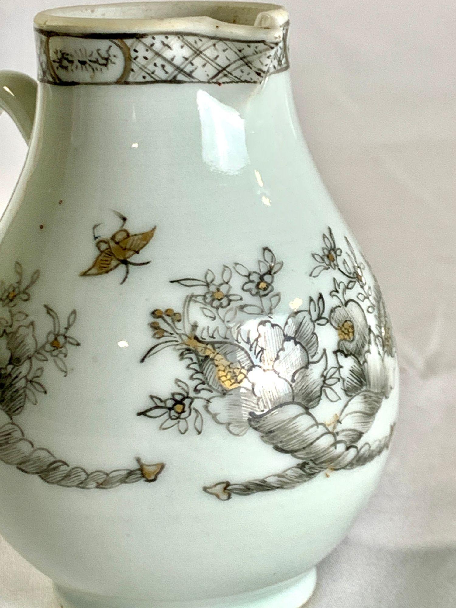 Dieser kleine Krug aus chinesischem Exportporzellan wurde von Hand in Grisaille mit zarten Goldtönen bemalt, eine Technik, die im 18. Jahrhundert wegen ihrer raffinierten Eleganz geschätzt wurde.
Das um 1770 entstandene, subtile Dekor zeigt fein