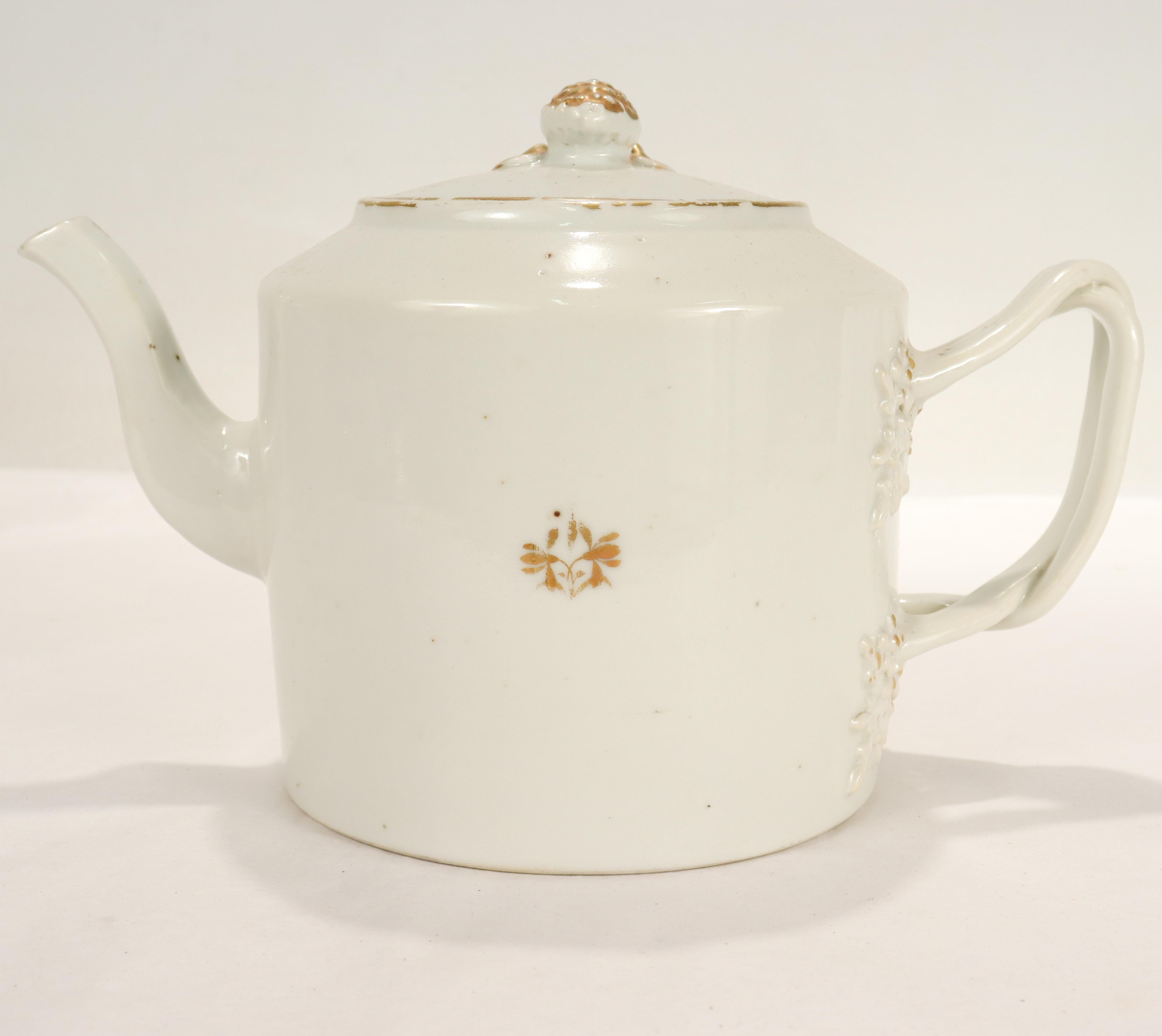A fine old or antique Chinese export porcelain teapot. 

Decorated throughout with faded gilding and raised figural floral devices

The C-shaped handle is in the form of branches with raised leaf decoration where the handle meets the teapot's