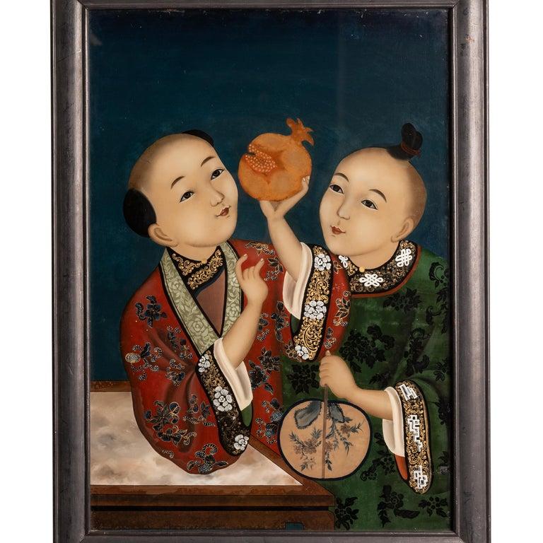 A very fine antique Qing dynasty Chinese export reverse painting on glass, circa 1860.
The painting depicts two children from the Imperial court, wearing very finely embroidered robes, one child is leaning on a marble topped table & holding a