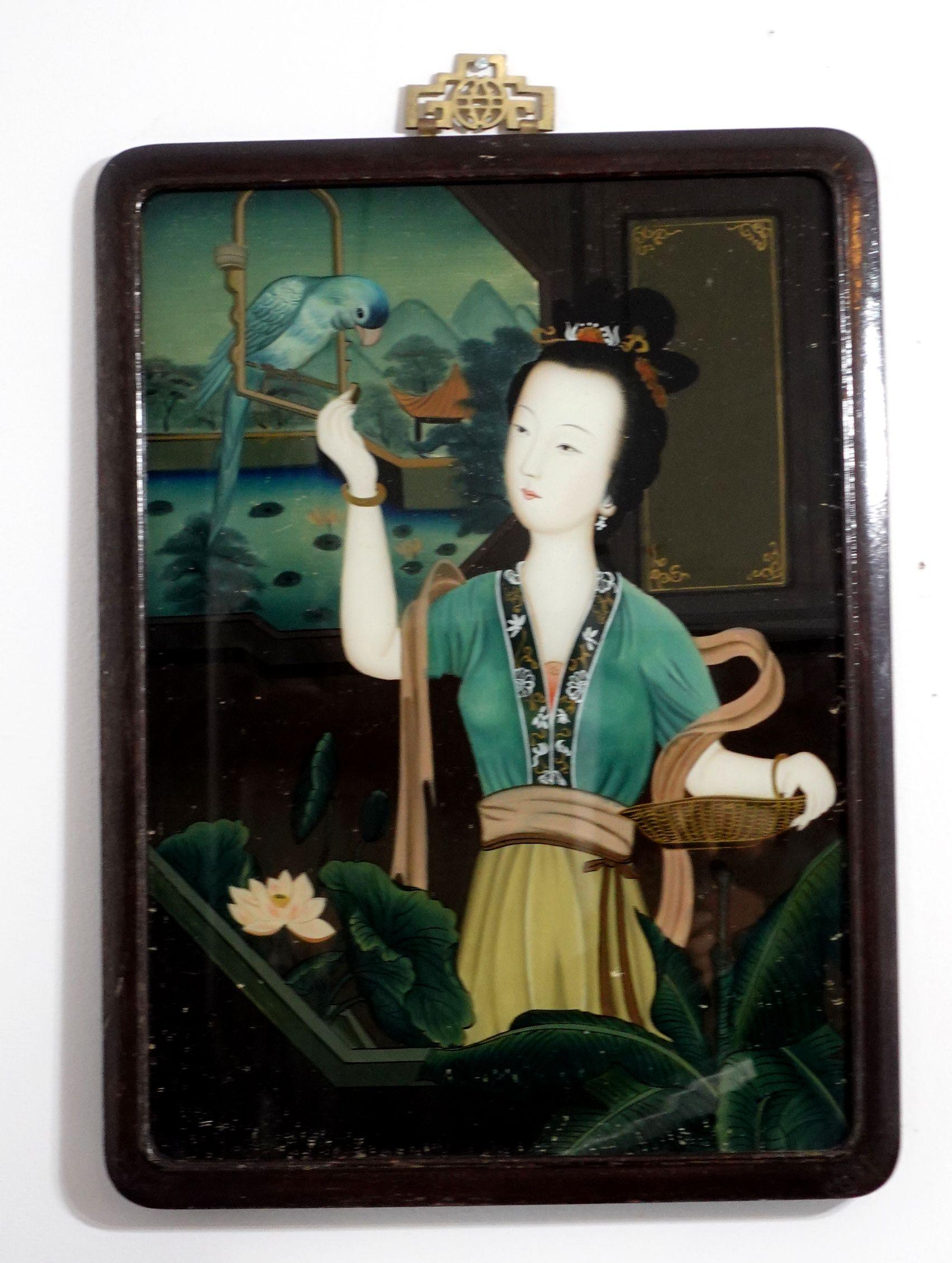Ein charmantes chinesisches Hinterglasbild aus dem späten 19. bis frühen 20. Jahrhundert, das eine Dame im Garten darstellt, die mit einem Vogel spielt. Das Gemälde wird mit dem originalen Hartholzrahmen und den alten Stiften auf der Rückseite der
