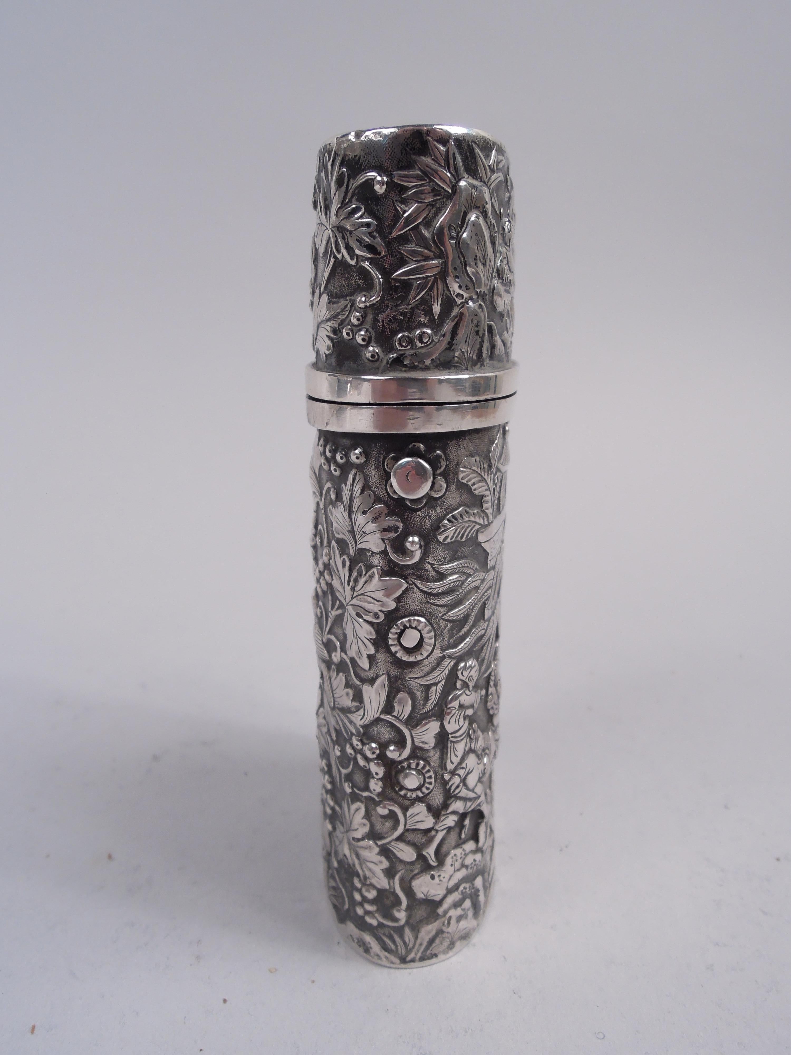 Chinese export silver cheroot case, ca 1860. Oval with hinged push-button cover. Allover repousse. On front are scenes of daily life with indigenous spearmen and sages, exotic pavilions in background. On back, perched birds on fruiting berry
