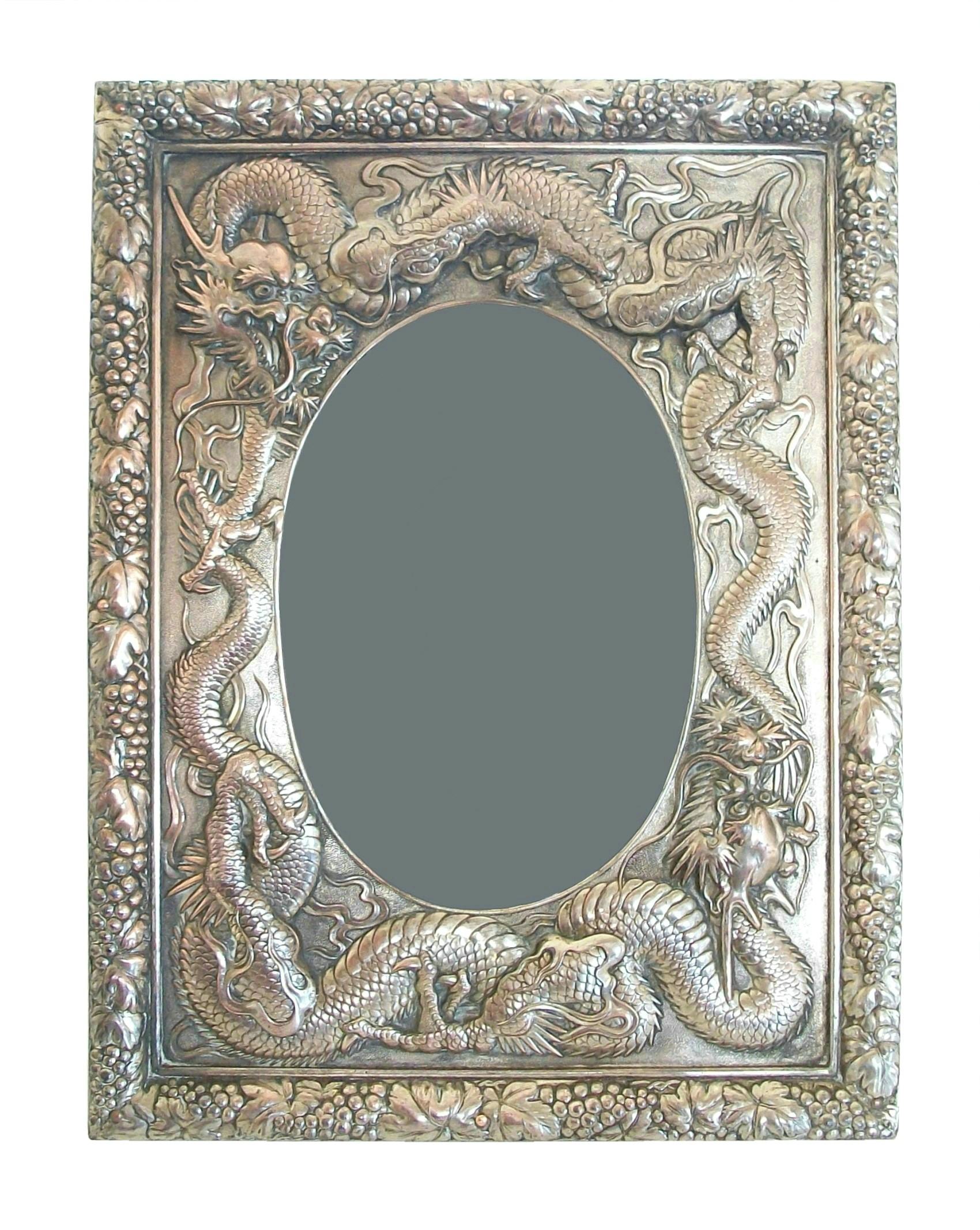 Antique Chinese export silver repoussé photo frame - silver content unknown - large size - oval opening - featuring dragons with fine detail in high relief surrounded by a border of leaves and grapes - warm aged patina over-all - free standing easel