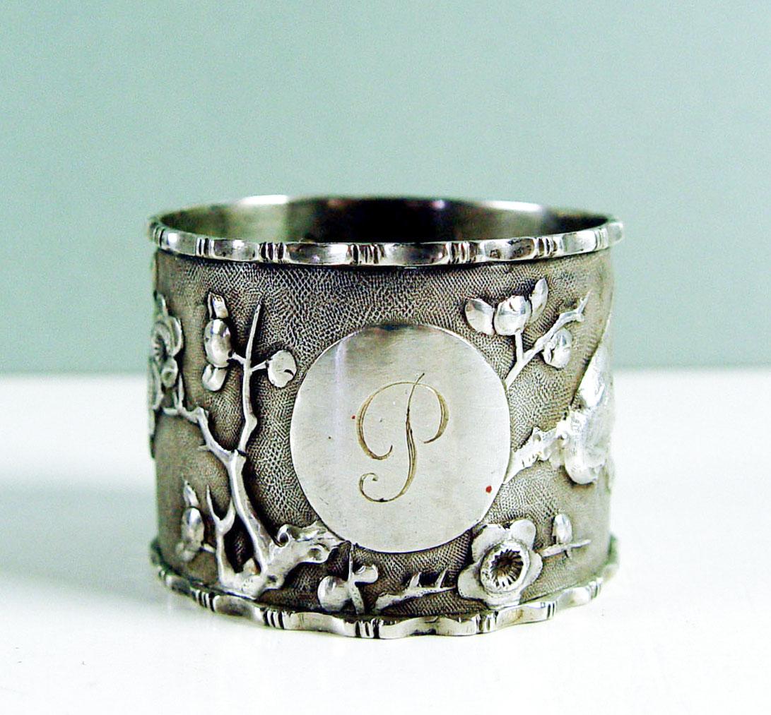 A single antique Chinese export sterling silver napkin rings circa 1900. With repousse cherry blossoms and birds, oval medallion with 