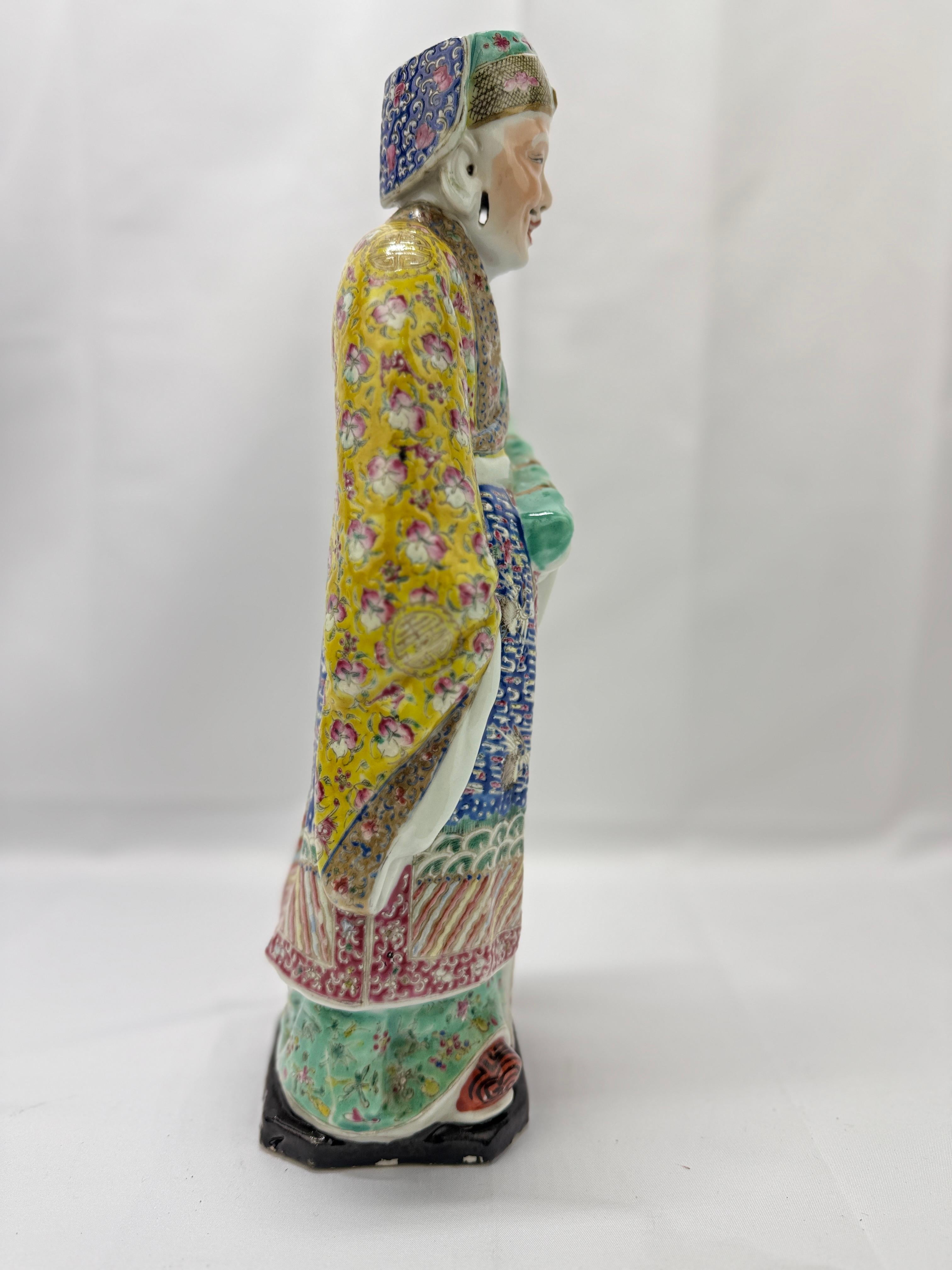 An antique Chinese porcelain scholar figure decorated in rich yellow, red, blue and green enamels across its surface. Fruit across the upper robe's sleeves and Phoenix figures to the main body. Marked to the underside. 

Measures:
14