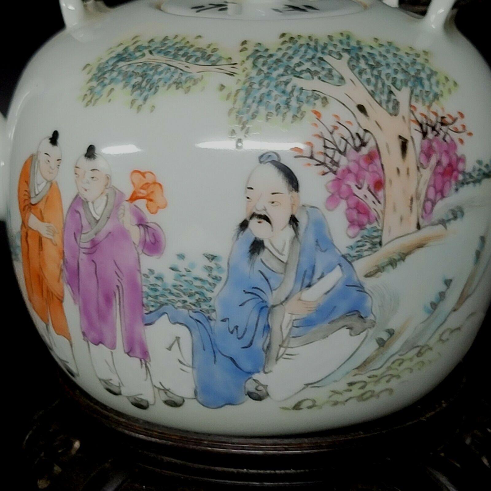 Théière en porcelaine chinoise Qianjiangcai avec signature de l'artiste et cachet d'époque sur le fond, représentant l'homme schalor enseignant à deux enfants dans le jardin, un exemple de la fin du 19ème siècle. support en bois inclus.

.