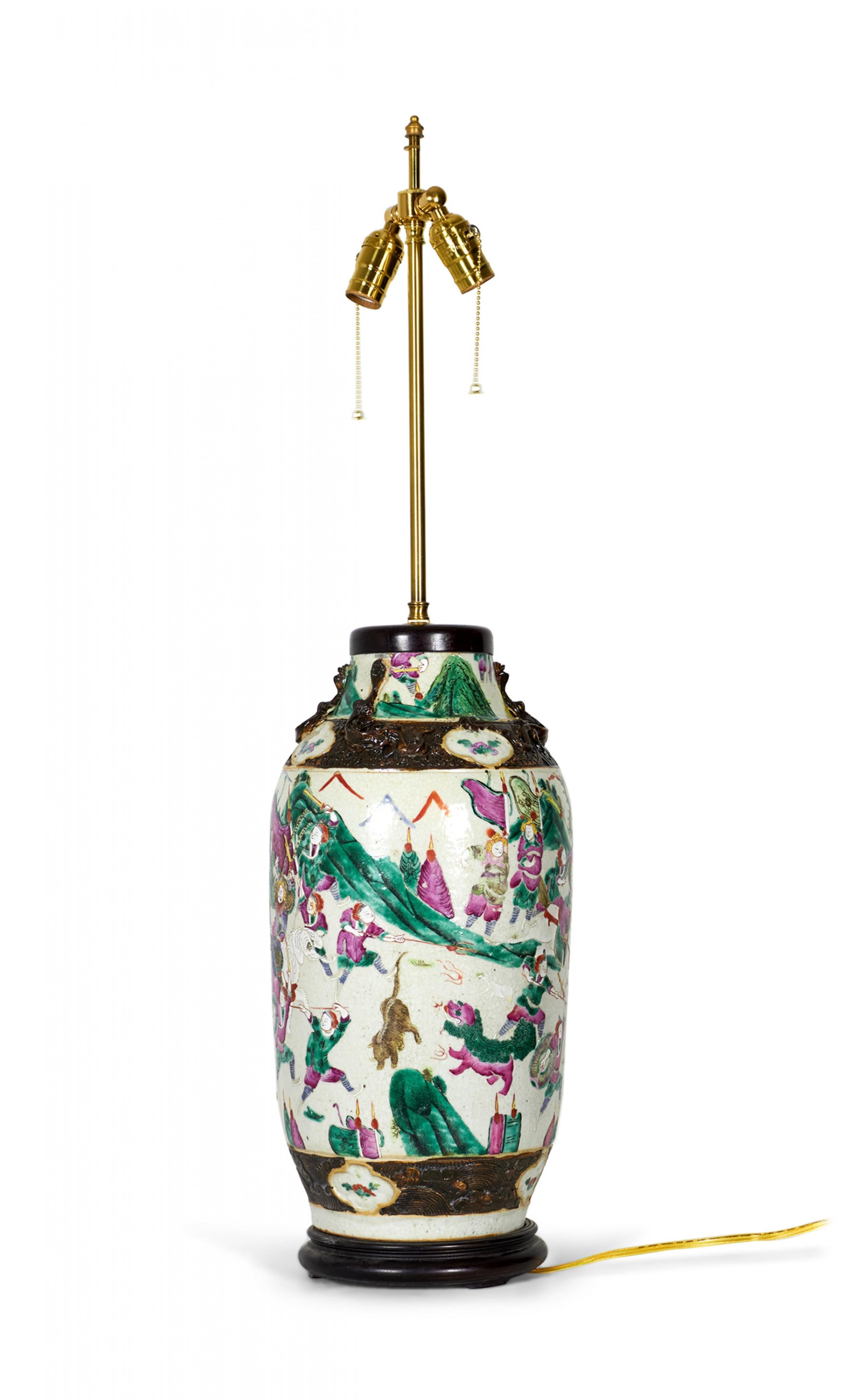 Lampe de table chinoise ancienne composée d'un vase en porcelaine du XVIIIe siècle monté avec du bois et des ferrures en laiton comme lampe, d'une famille rose multicolore et d'une scène de genre représentant une procession sur un fond beige. (Lampe