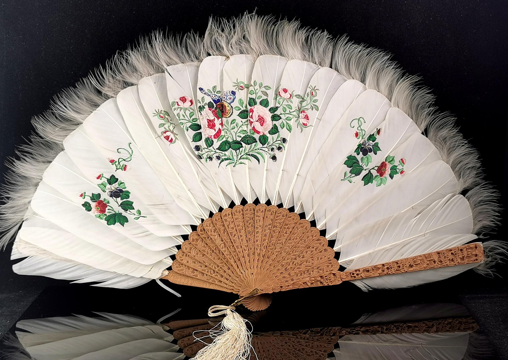 A beautiful antique, Art Deco era Chinese feather and silk hand fan.

The fan is made from off white coloured feathers with tufty edges and silk, attached to bamboo sticks and finely carved wooden guards.

The feathers have a gorgeous hand painted