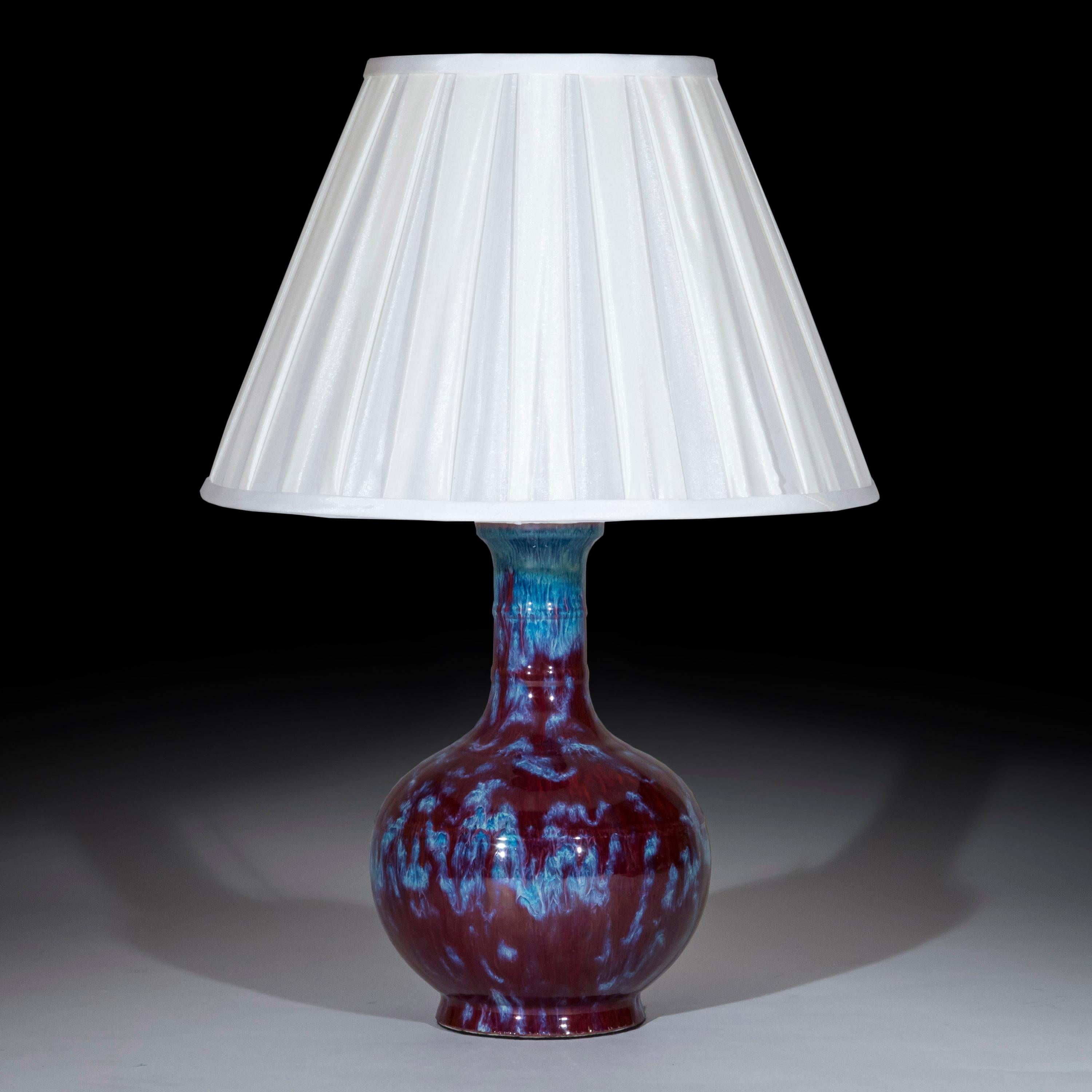 An absolutely superb, very decorative flambé glazed early 20th century pottery vase, mounted as table lamp
China, circa 1900s.

Why we like it
Its most beautifully contrasting blue and aubergine colored flambe glazing make this bottle vase a