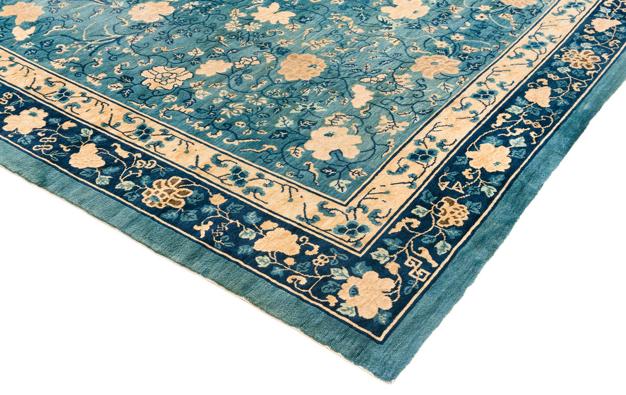 This room size antique was woven in China toward the end of the 19th century. It features a traditionally Chinese design with an intricate all-over floral pattern in ivory on a blue background.  Size:  9'10 x 13'9