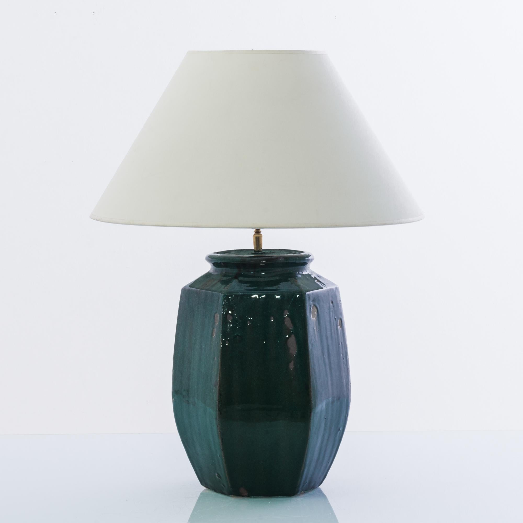 A vintage Chinese vase, fitted with an adjustable brass fixture and E26 lighting socket. The deep tone of the forest green glaze creates a vivid visual impact. Textured glazes, attractive colors and faceted shape grants a sensuous tactility to the