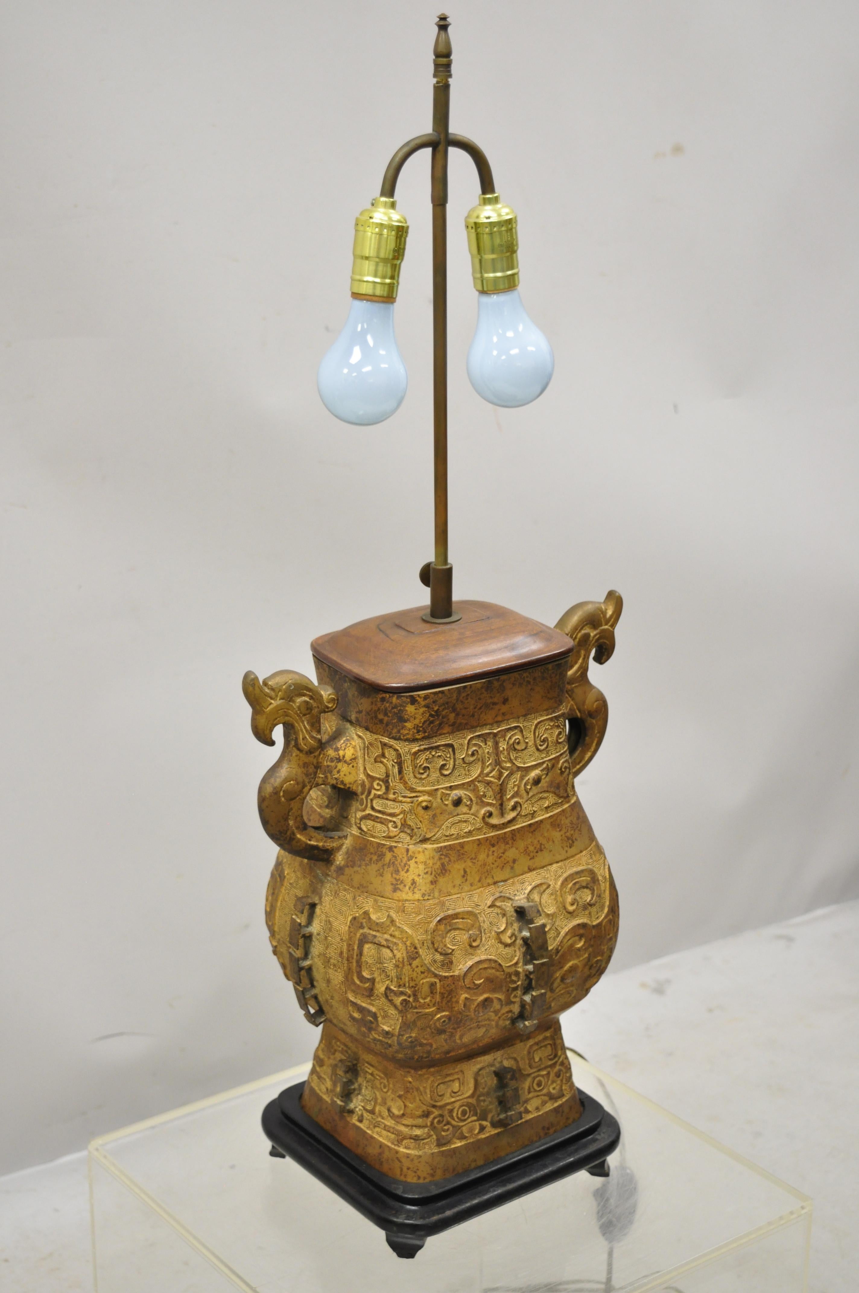 Antique Chinese gilt bronze and rosewood figural double light table lamp. Item features etched bronze figural body, rosewood and brass accents, wooden base, double light sockets, very nice antique item, circa early 20th century. Measurements: 34