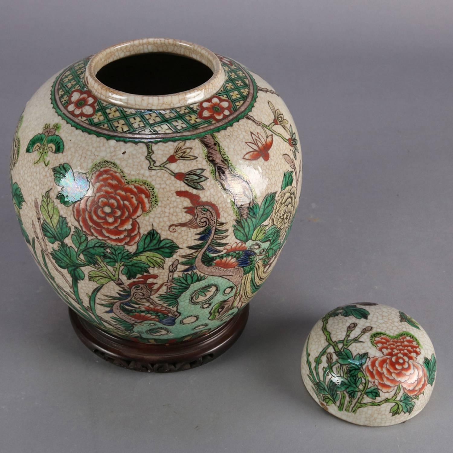 Antique hand-painted Chinese porcelain ginger jar with garden and pond motif, signed on base, seated on carved and pierced rosewood stand, 19th century

Measures: 12.5