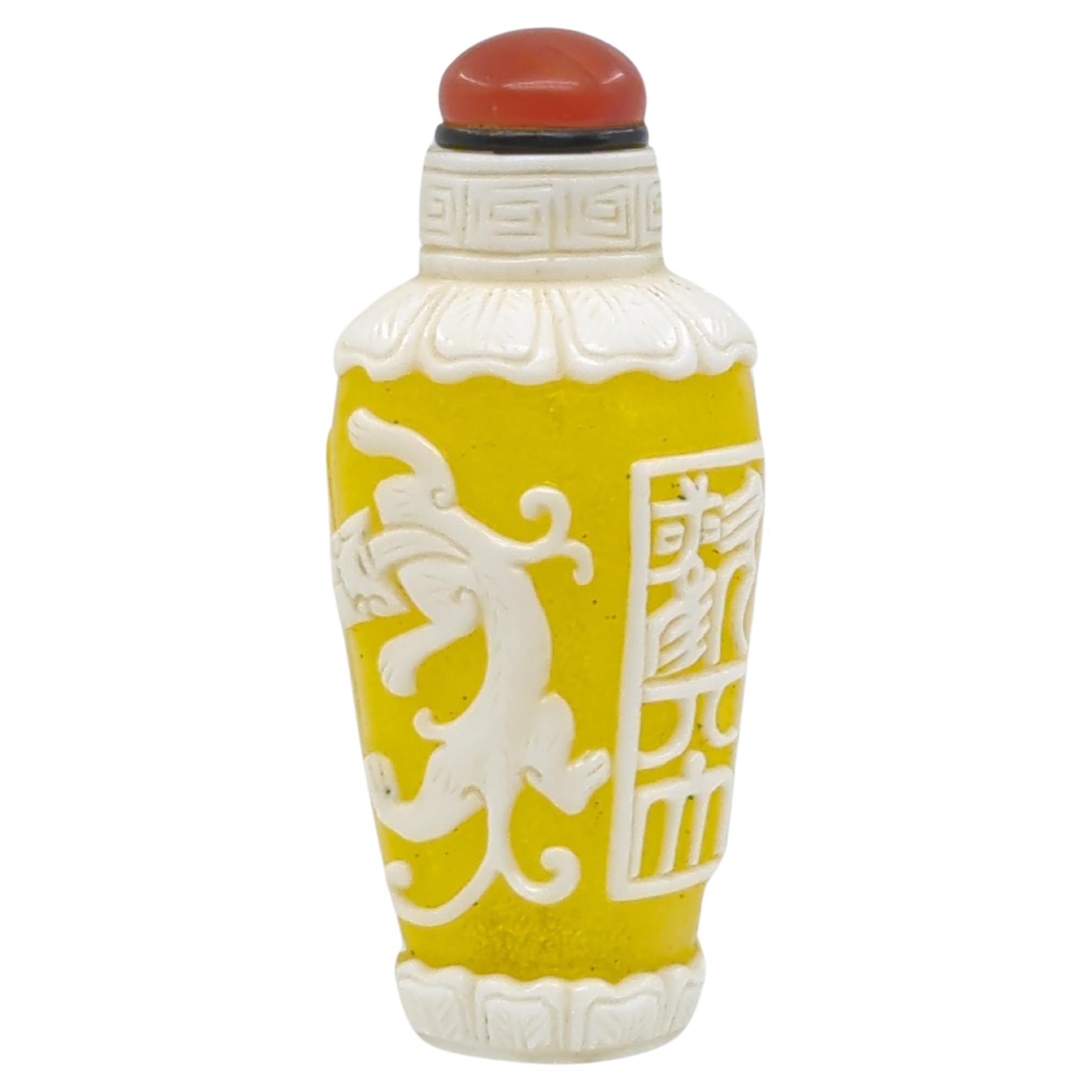 This mid 20th-century Chinese glass overlay snuff bottle is a fine example of the intricate overlay technique. The bottle, of tapered rectangular form, features a captivating design with two Qilins (Kirin), a mythical Chinese creature, depicted in
