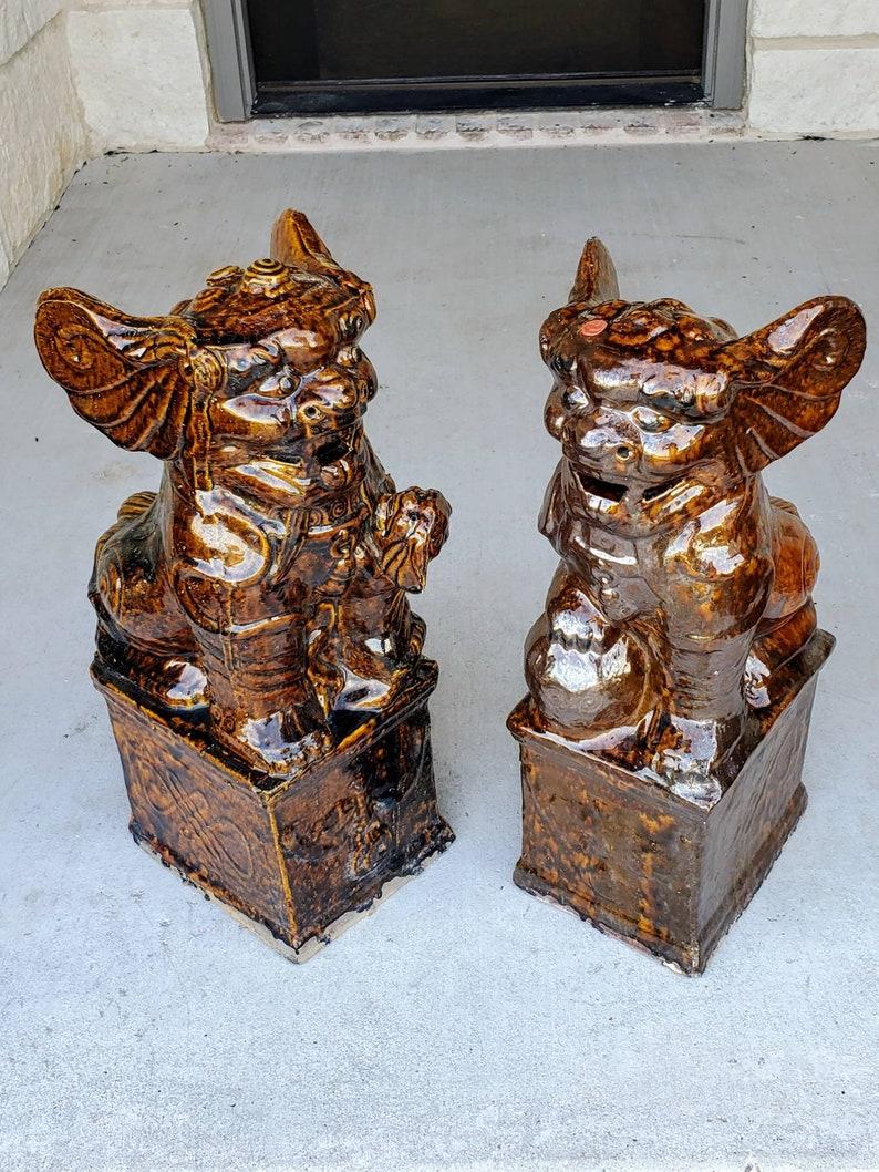 A magnificent pair of large antique Chinese porcelain temple Guardian Lions - Foo Dogs. The near matching male and female pair of handcrafted architectural ornaments present superbly, with rich dark brown glaze, warm hues of burnt orange and the