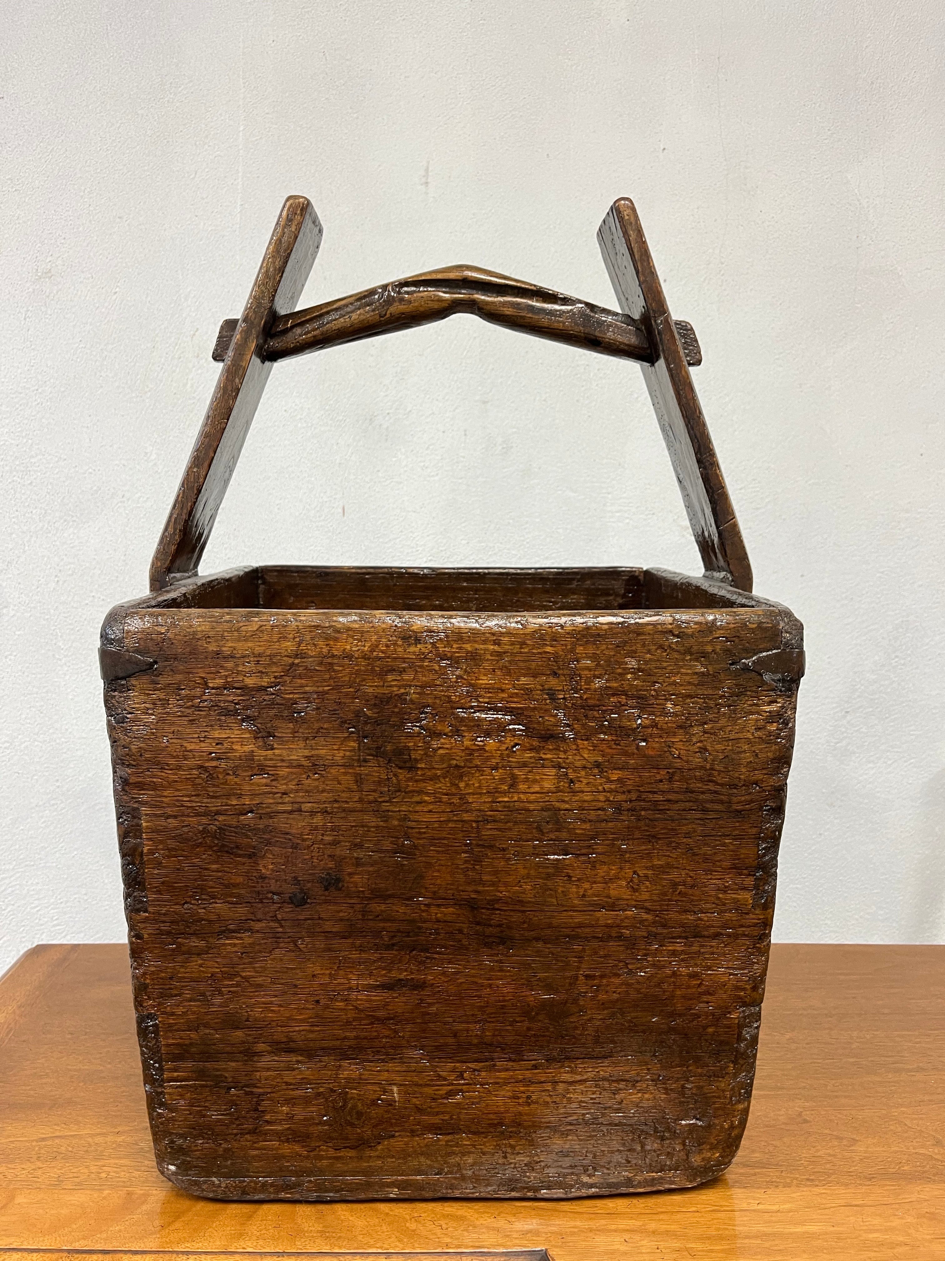 Splendido cesto di grano cinese. Forma semplicistica ma funzionale. Angoli a coda di rondine fissati con supporti metallici. Chiodi in metallo sul manico. Maniglia del giogo per la vittoria. 