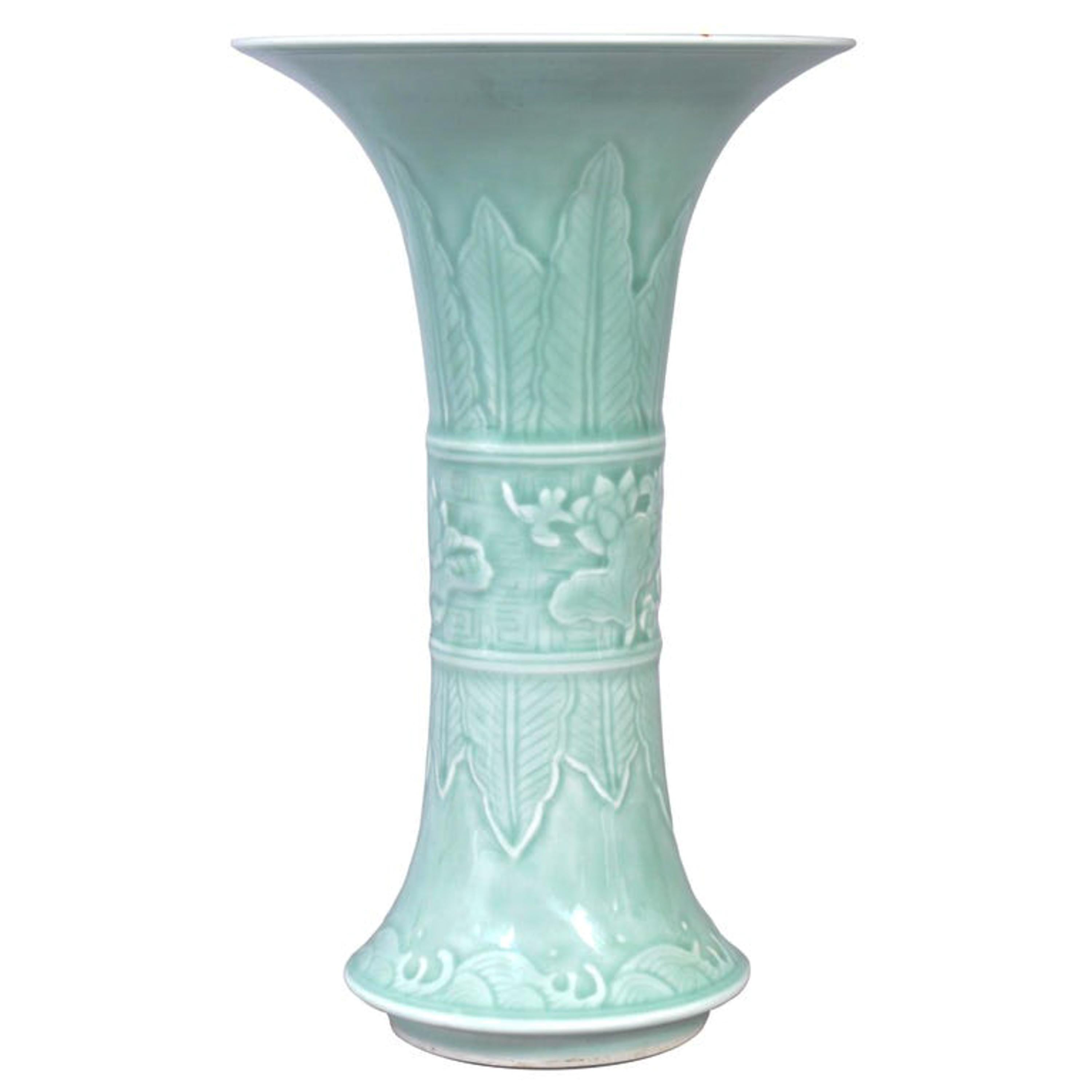 A fine antique 19th century Chinese Qing dynasty Imperial green Celadon Gu shaped porcelain vase, circa 1850.
The vase of Gu shape, originally an ancient shaped tall and slender wine vessel with a flared base, tapering to a slim waist and a trumpet