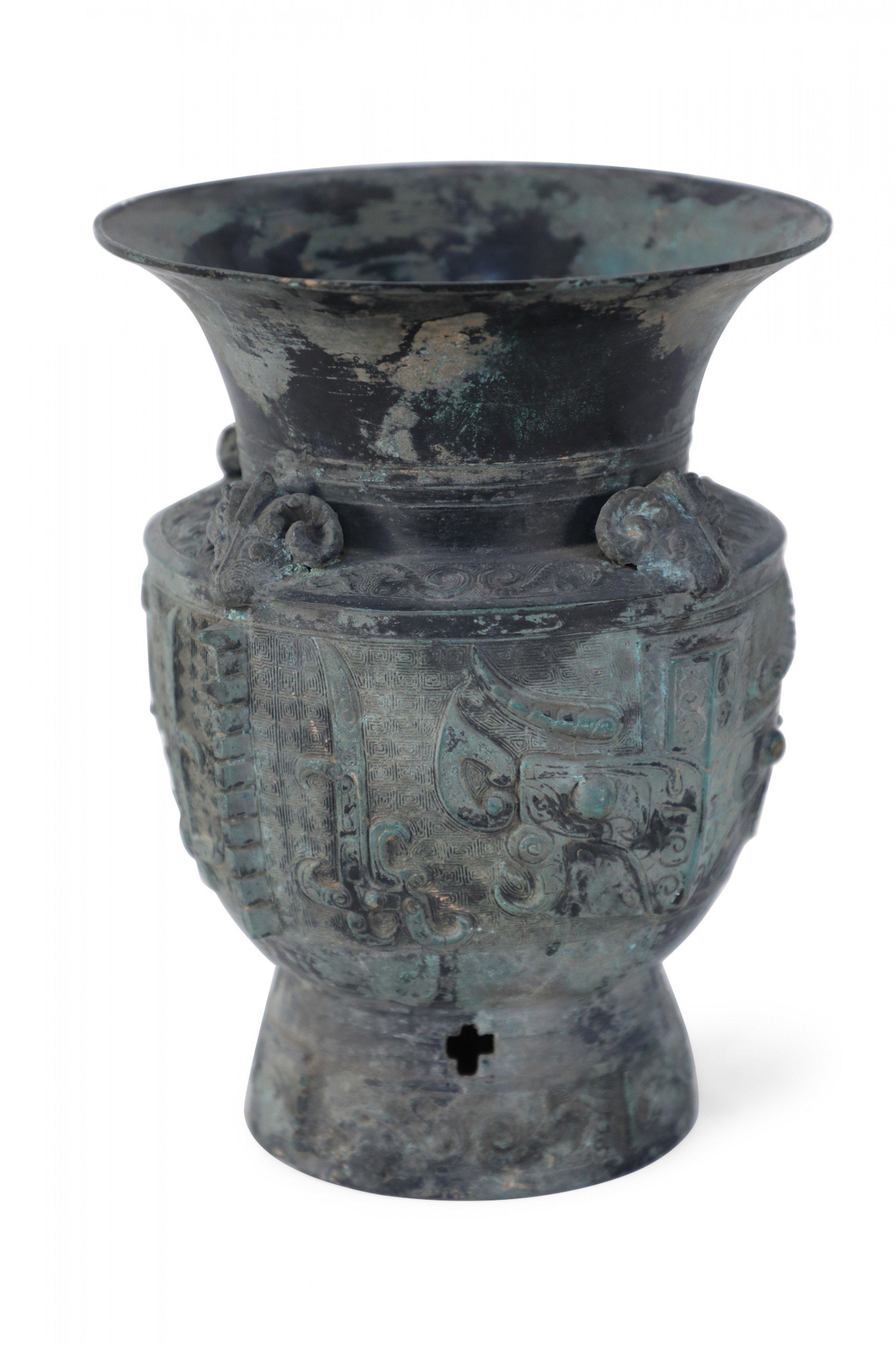 Antica copia in stile Dinastia Han cinese di un'urna in bronzo patinato con ornamenti a testa di ariete sotto la bocca scanalata, motivi geometrici in rilievo che avvolgono il corpo e un piede circolare affusolato con intagli a forma di croce.