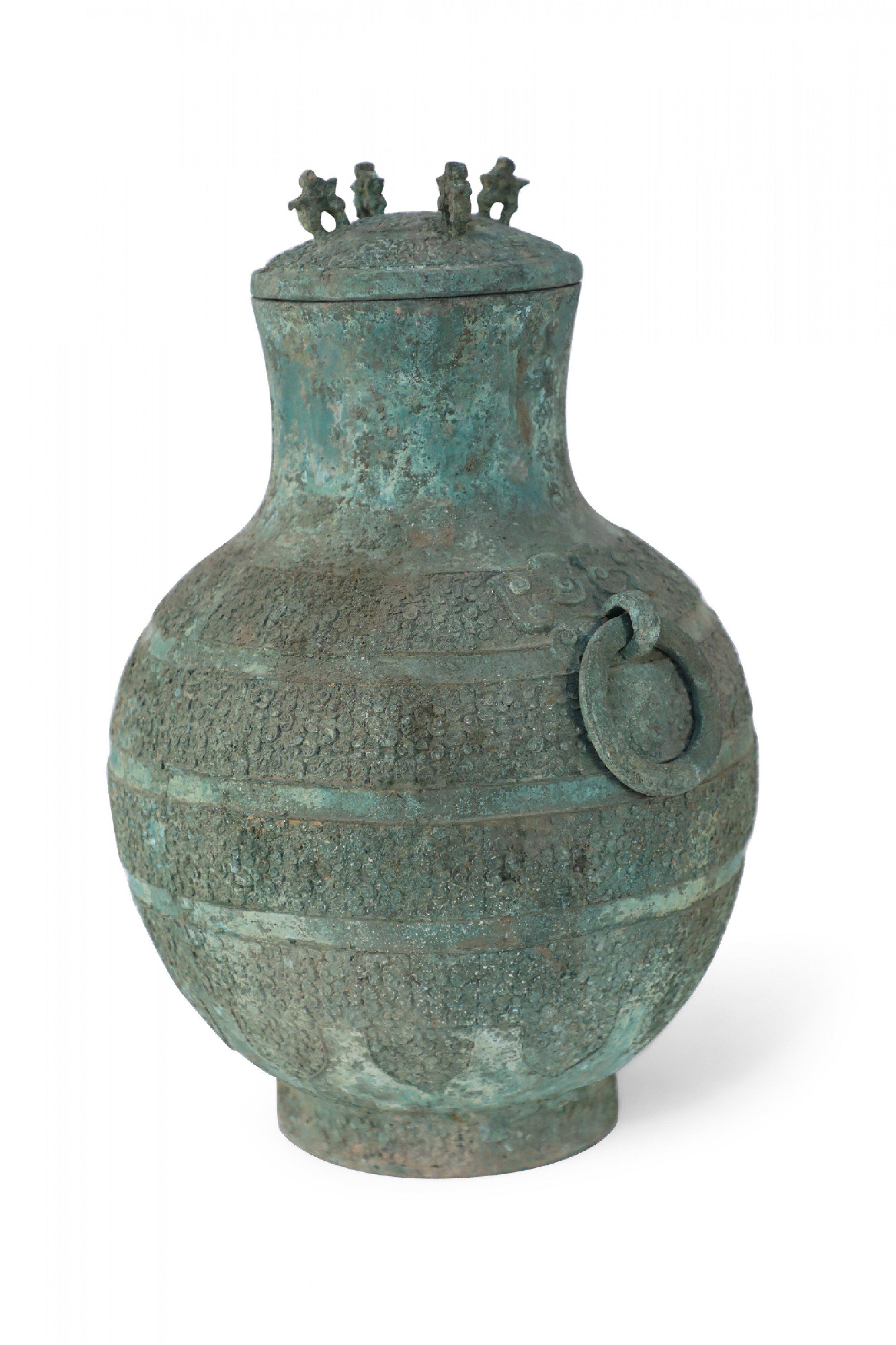 Antique Chinese Han Dynasty-style verdigis bronze ritual wine vessel with an archaistic raised banded pattern, a domed lid with zoomorphic-shaped loops, two decorative rings on the sides and a circular foot.