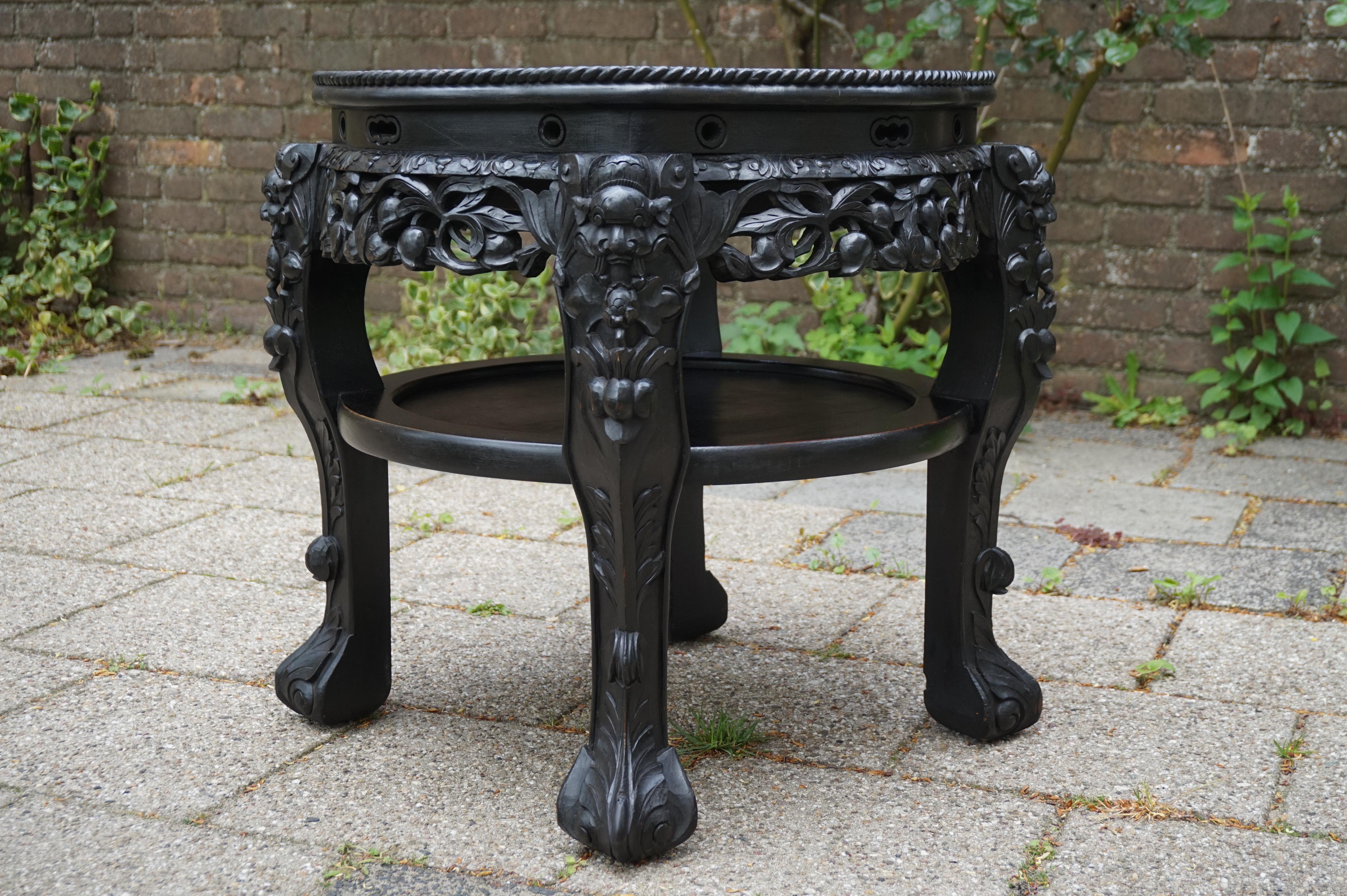 Large, stylish and incredibly decorative Chinese table / stand.

This entirely handcrafted, Asian table from circa 1890-1900 is as stable as the day it was made and it has a very attractive shape and color. The hand carved, mythological dragons atop
