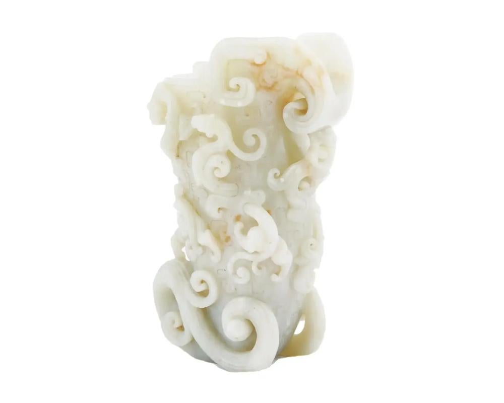 An antique Chinese hand carved white hard Jade vase. The vase is decorated with relief dragon and waves patterns, and engraved detailed motifs. Circa: early 20th century. The item, probably, comes from the Hotan region, the main source of the
