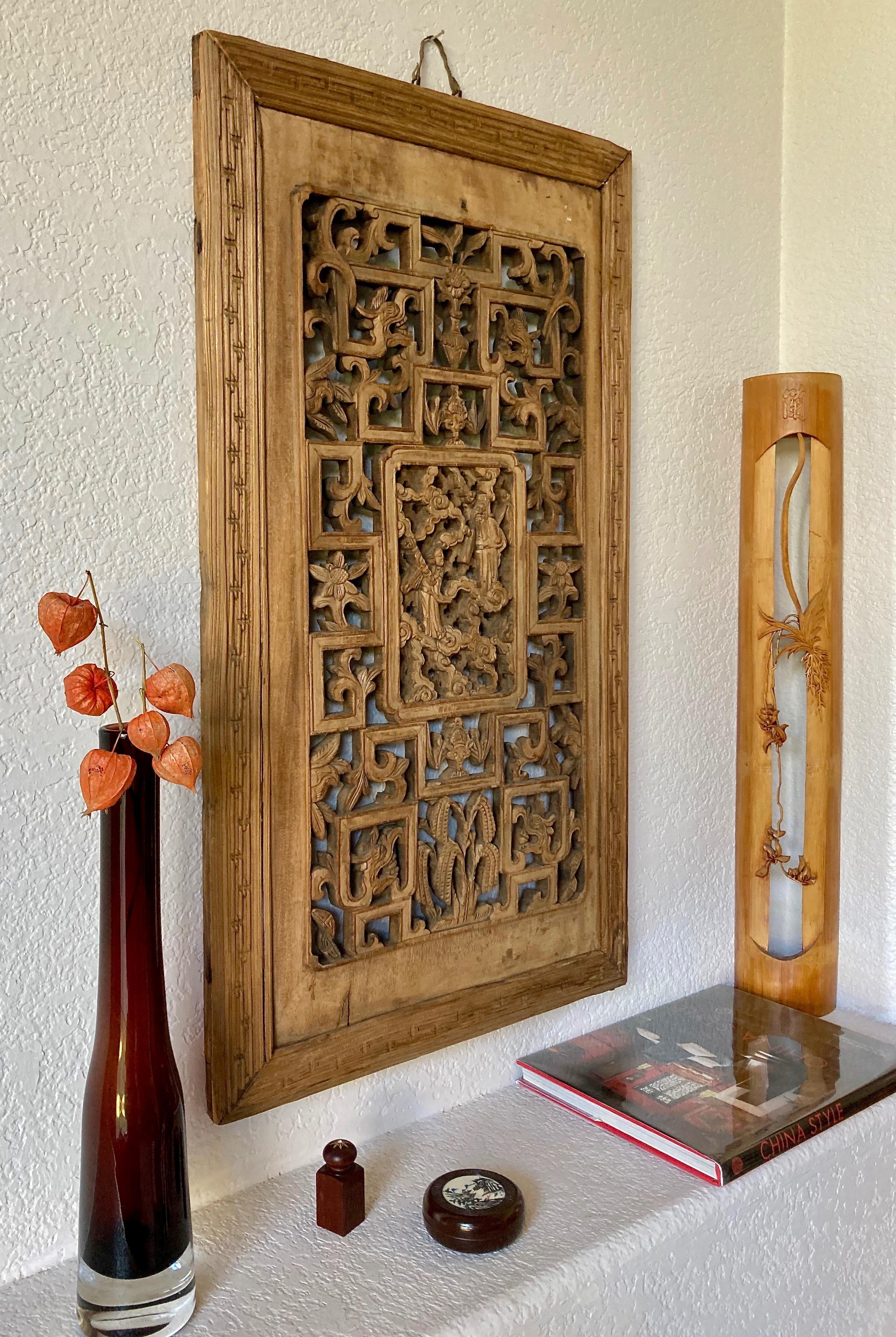 This elegant piece includes a rectangular center carving with personage and surrounding dragon, bat and floral motifs. Hand carved from a single piece of wood with an ornamental frame.