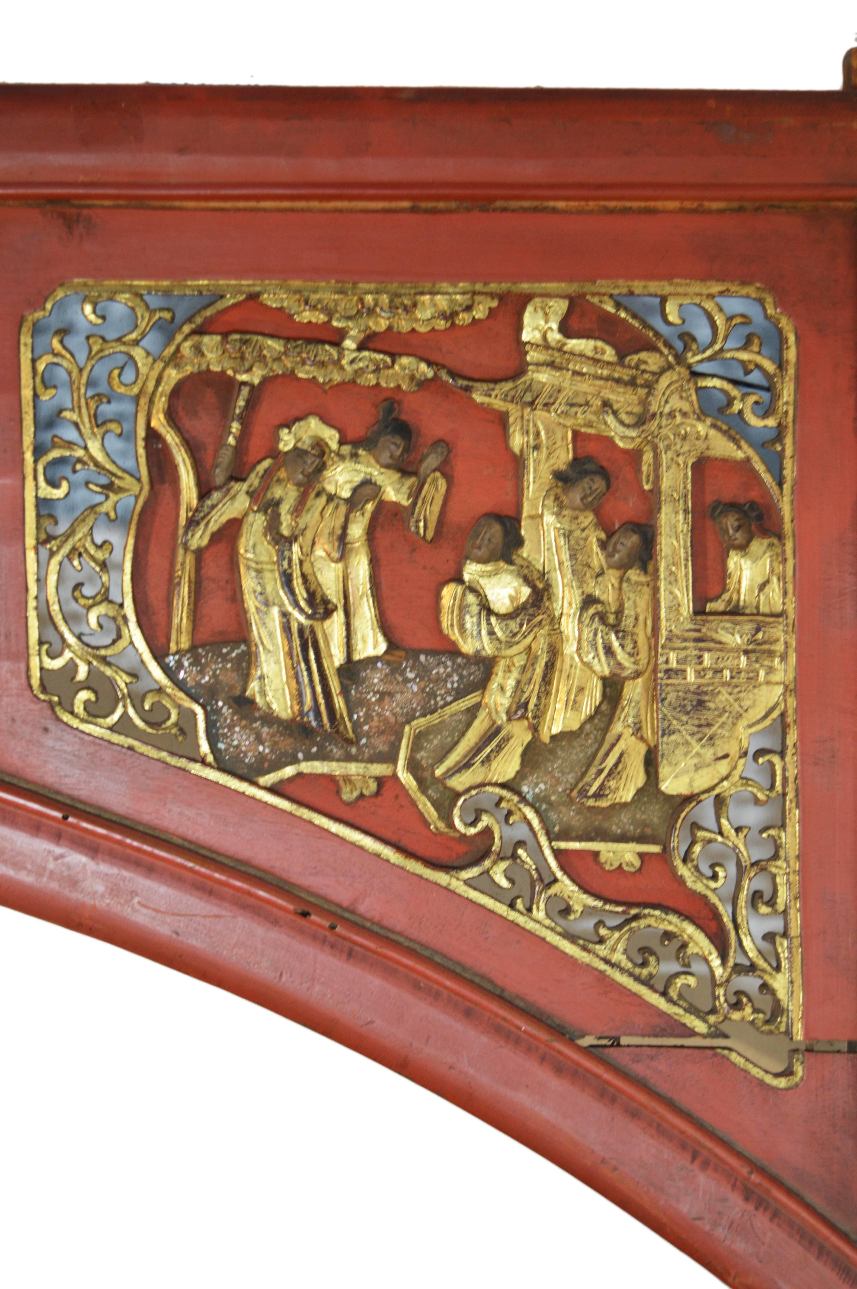 A 19th century Chinese sign with scenes, hand-carved from wood and painted. This large wooden sign, which may have sat above a doorway or even part of an elaborate bed, adopts a curved shape and features three compartments with scenes. This red