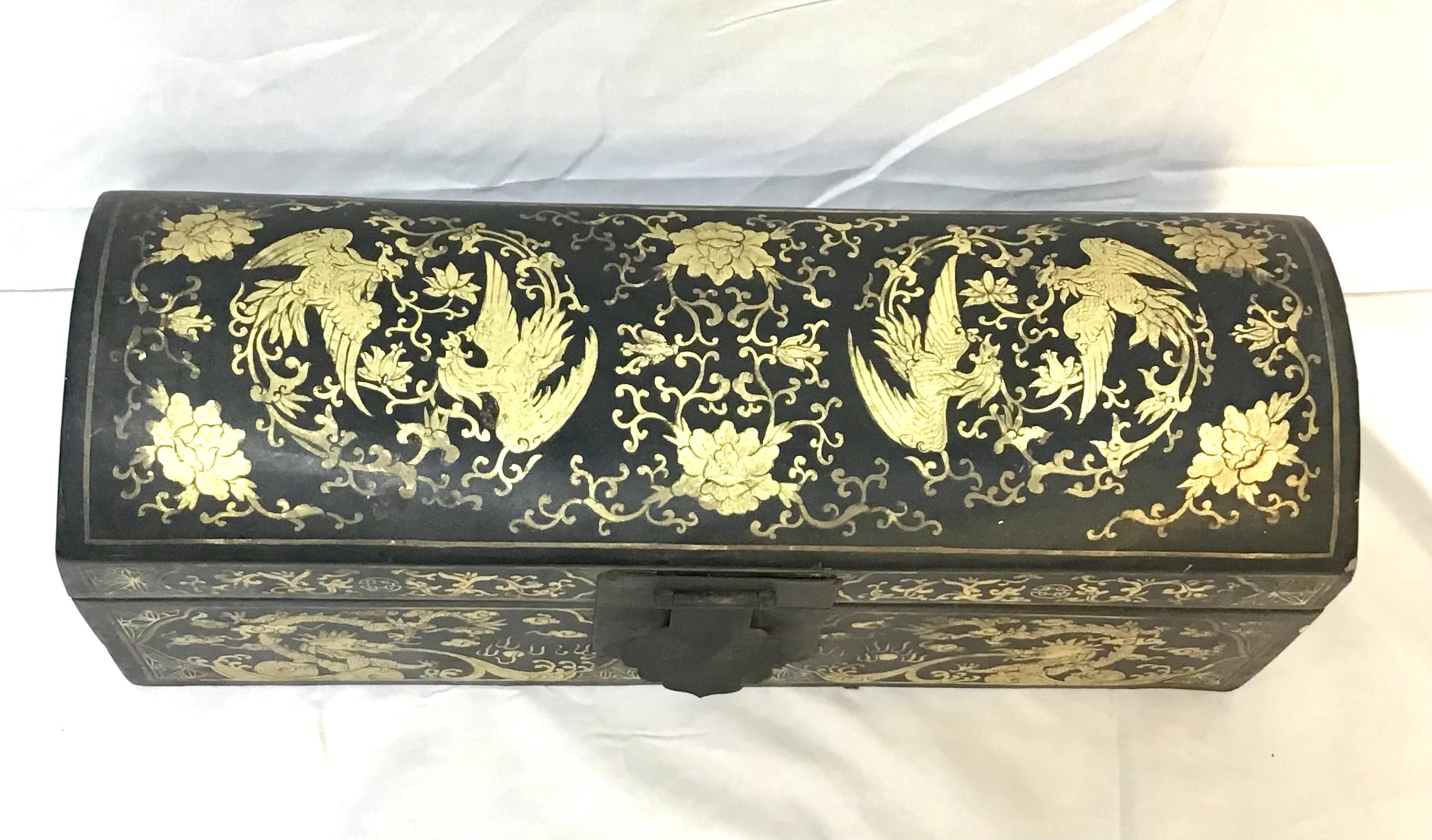 Early 1900's Antique gilt chinoiserie decorated hinged wooden pillow box originally used as a pillow and a place to store ones valuables while sleeping. The box features fine gilt decoration with a curved top, two brass handles and a brass lock