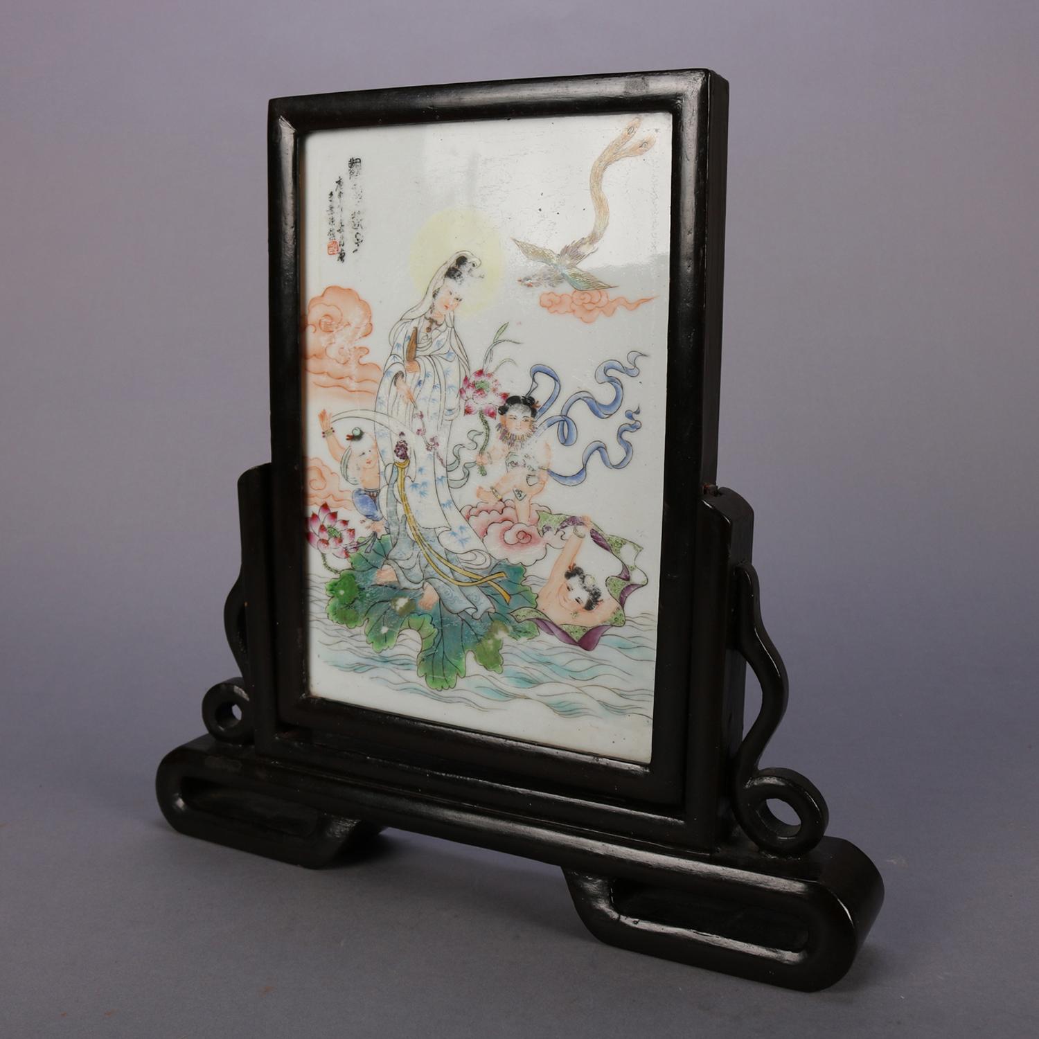 Chinese table screen features hand-painted porcelain plaque with woman in garden setting with top left chop mark inscription and seated in carved and ebonized hardwood stand, 19th century

Measures: 13.75