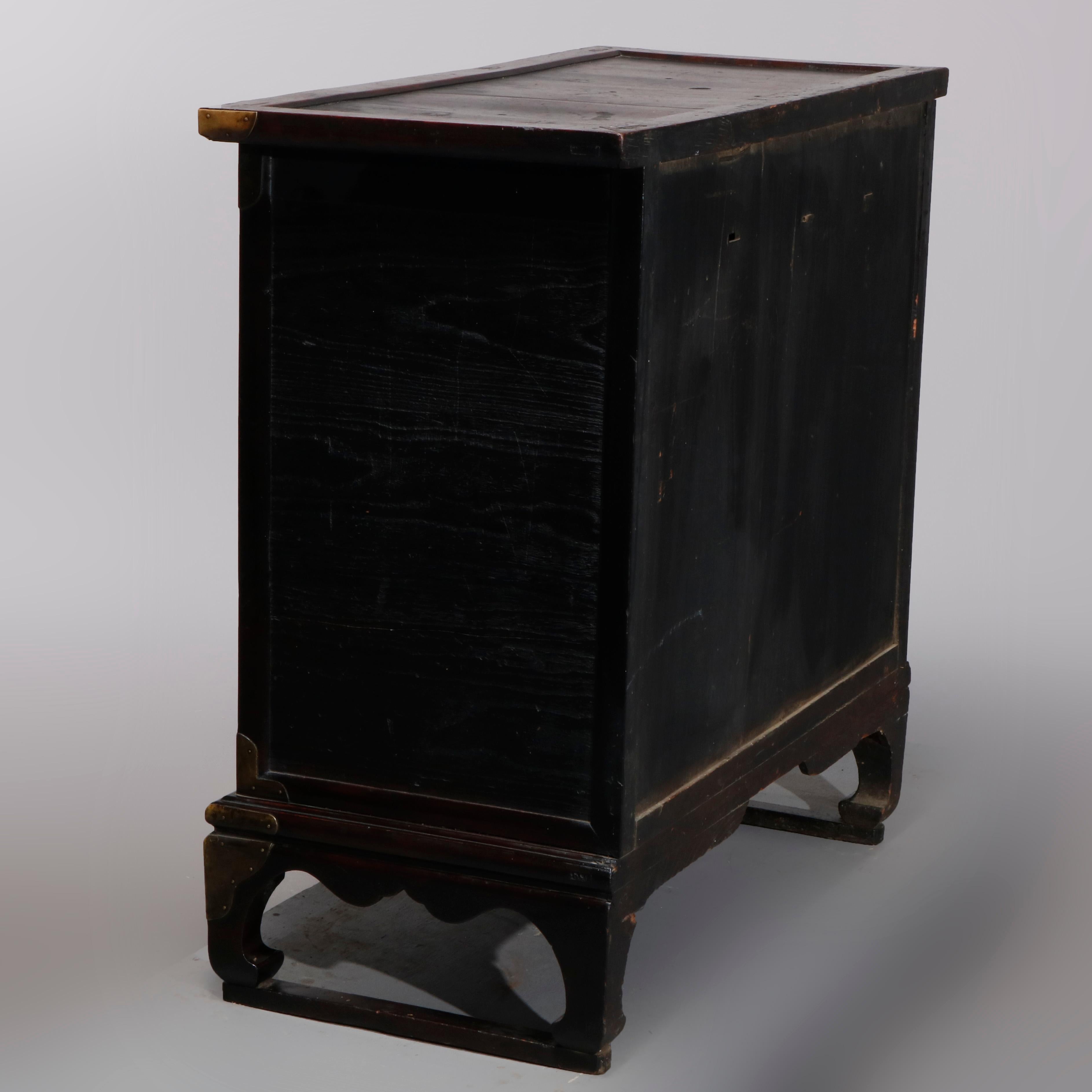 An antique Chinese tea cabinet offers construction with drawers and cabinet, raised on bracket feet, brass hardware throughout, 19th century.

Measures- 37.5