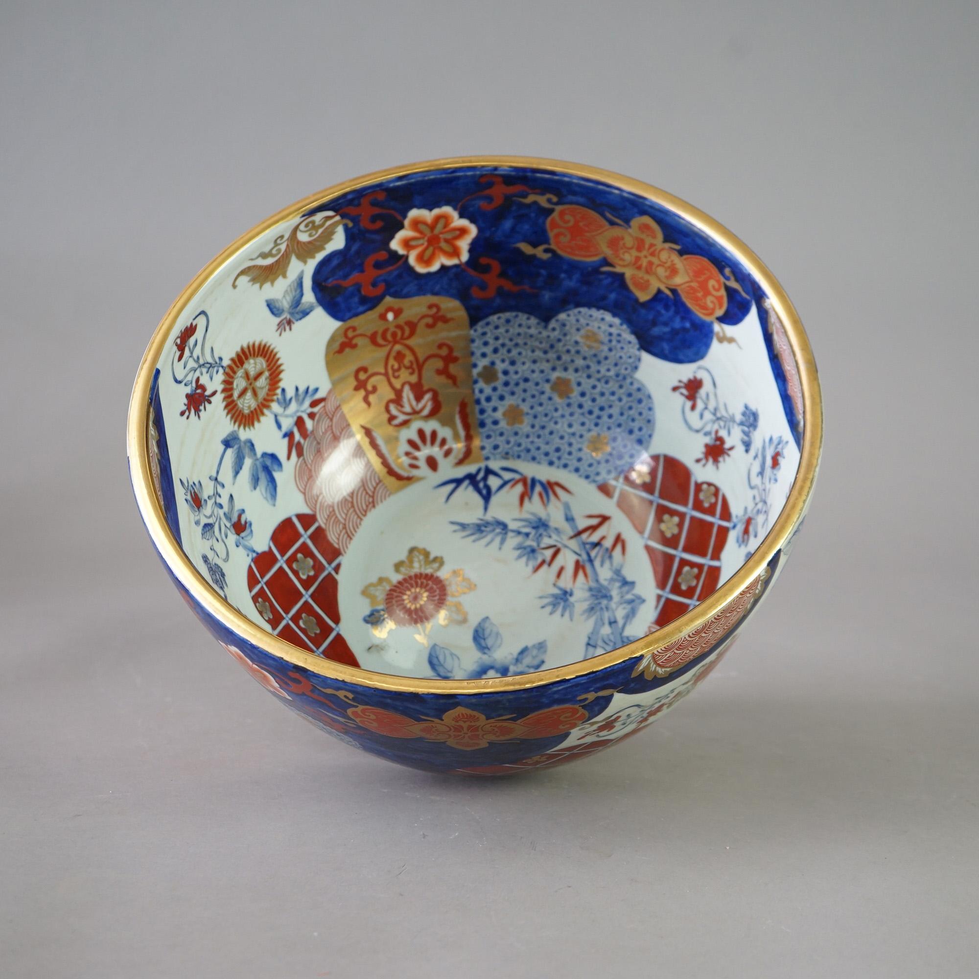 An antique Chinese Imari oversized center bowl offers porcelain construction with hand painted garden elements and gilt highlights throughout, c1920

Measures - 7.75