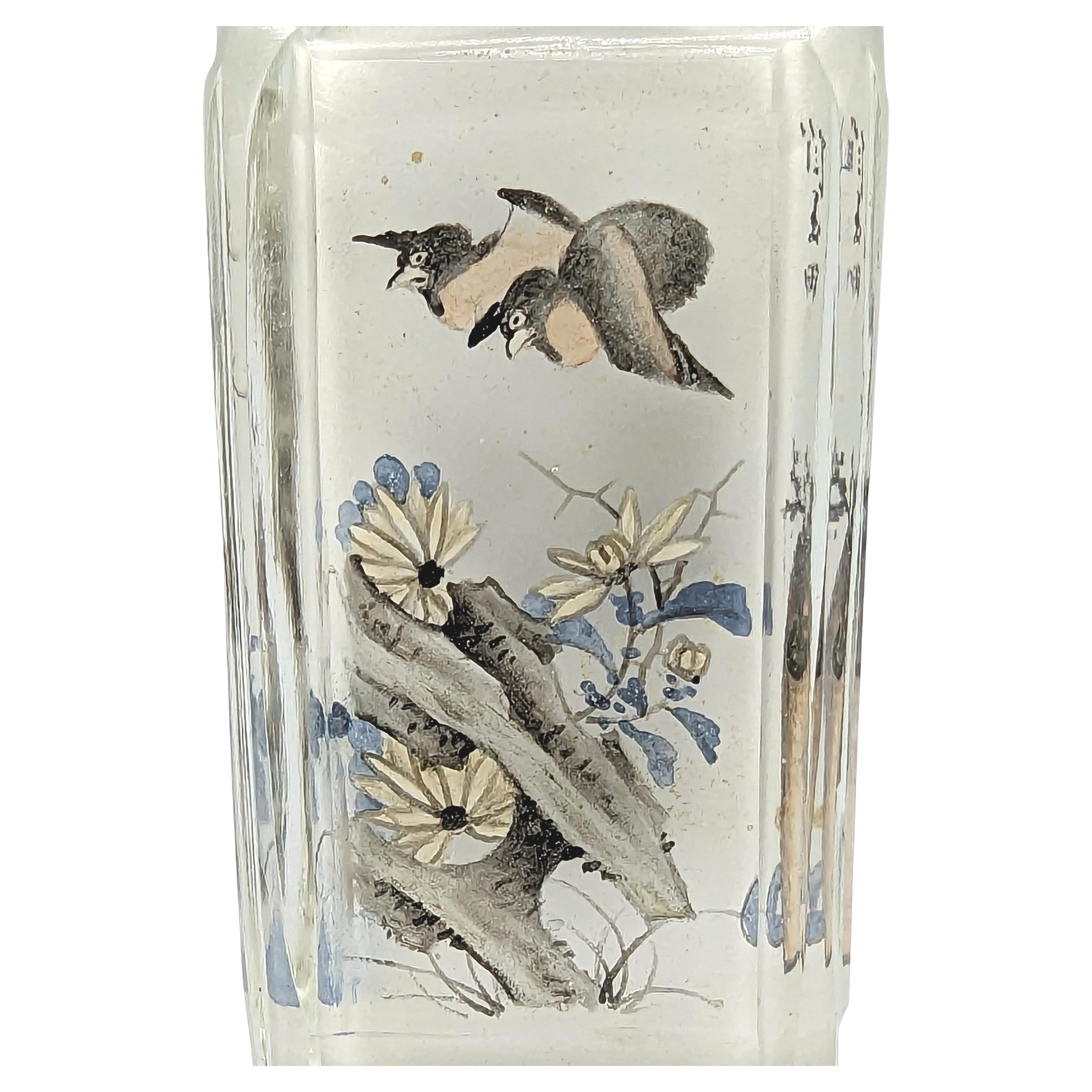 An antique Chinese inside painted glass snuff bottle, finely painted on four  faceted panels with two people in a mountainous landscape scene, two birds in a rocky garden scene, two insects in a turnip and flowers scene, and two plants in pottery