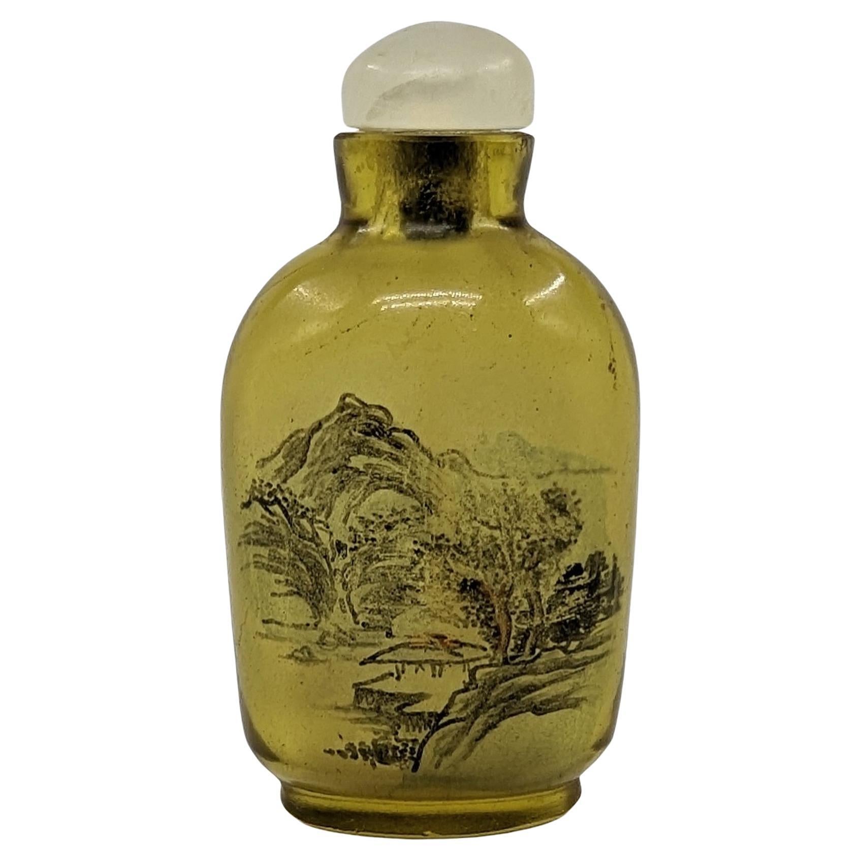 An antique Chinese inside painted yellow glass mini snuff bottle with a translucent hardstone stopper. This wonderful little bottle is inside painted with a resting bird in a tree to one side and a landscape to verso, well painted and unsigned

Late