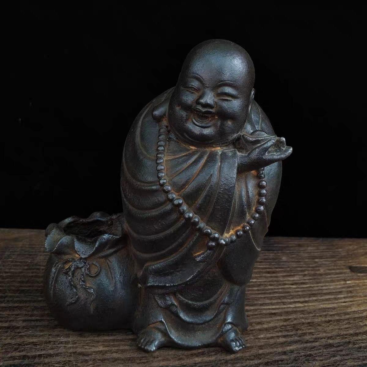 Esta estatua china vintage de hierro de Buda sonriente irradia alegría, suerte y prosperidad. Conocido como Budai o el Buda Risueño, esta querida figura se representa con una expresión alegre, sentado cómodamente con una bolsa llena de lingotes de