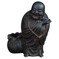 Chinesischer eiserner glänzender Vintage-Buddha mit einer Tasche aus goldenen Ingots