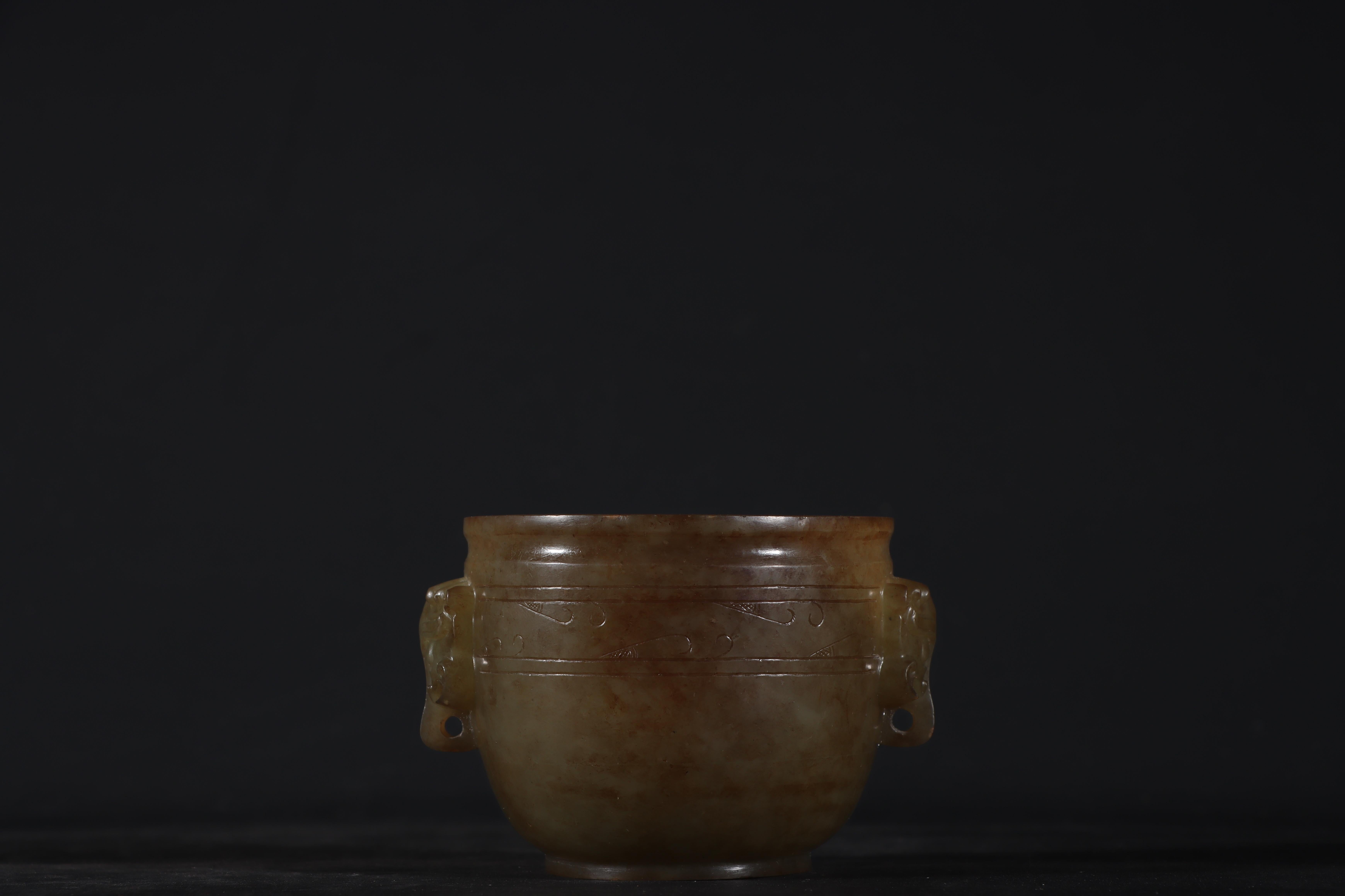 This exquisite antique Chinese jade cup features two intricately carved beast head ears, a design symbolizing strength and protection in traditional Chinese art. Handcrafted with exceptional precision, this jade vessel showcases the remarkable