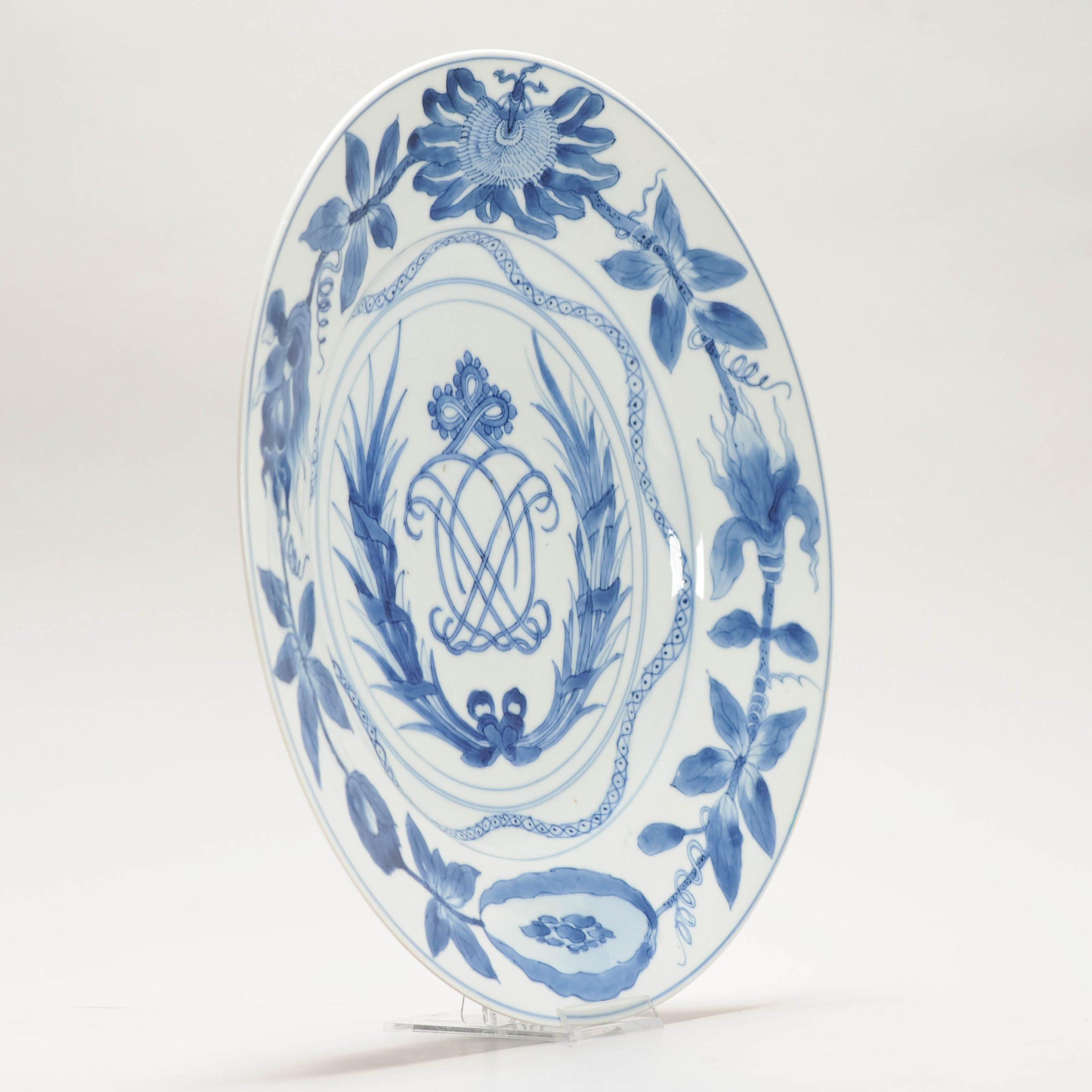 Kangxi en todo su esplendor
Plato chino azul y blanco del mercado europeo, Kangxi (1662-1722), decorado en el centro con un monograma sobre una corona de laurel y un nudo de amor encima, el borde con una guirnalda de pasiflora frutal, el reverso con