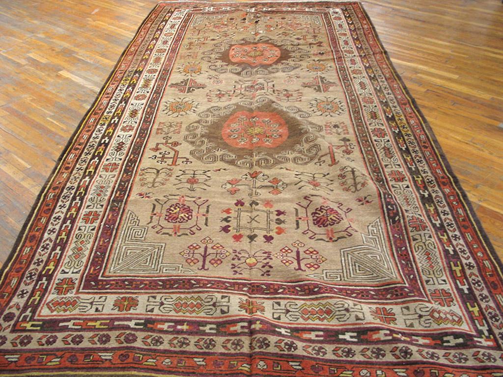 Late 19th Century Central Asian Khotan Carpet with a tan background and patterned border.
 ( 6'9