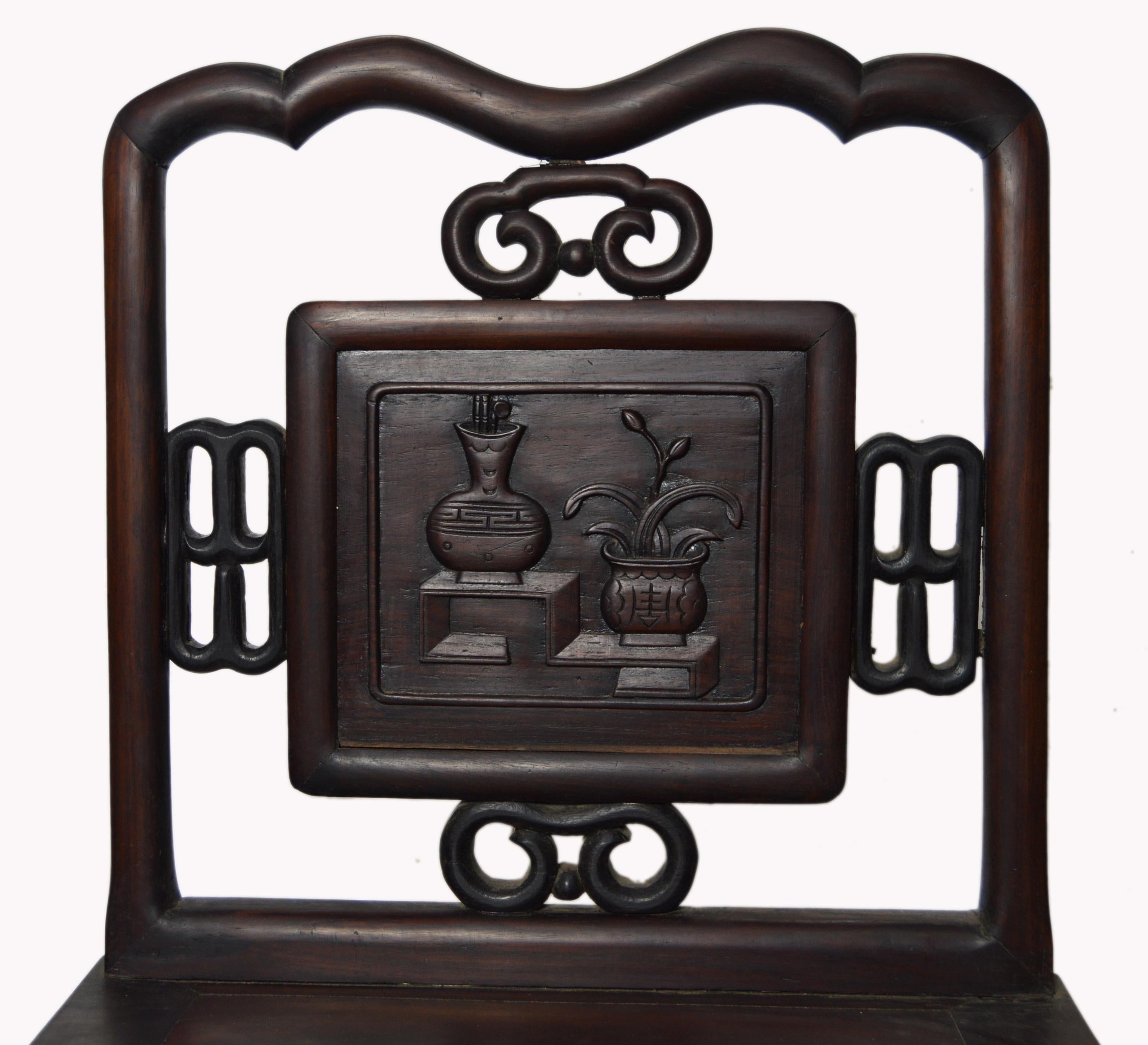 A hand-carved Chinese yumu wood accent chair from the early 20th century, with dark brown lacquer finish, fretwork motifs and carved splat. This exquisite Chinese side chair features a rectangular pierced back with undulating crest, adorned with a