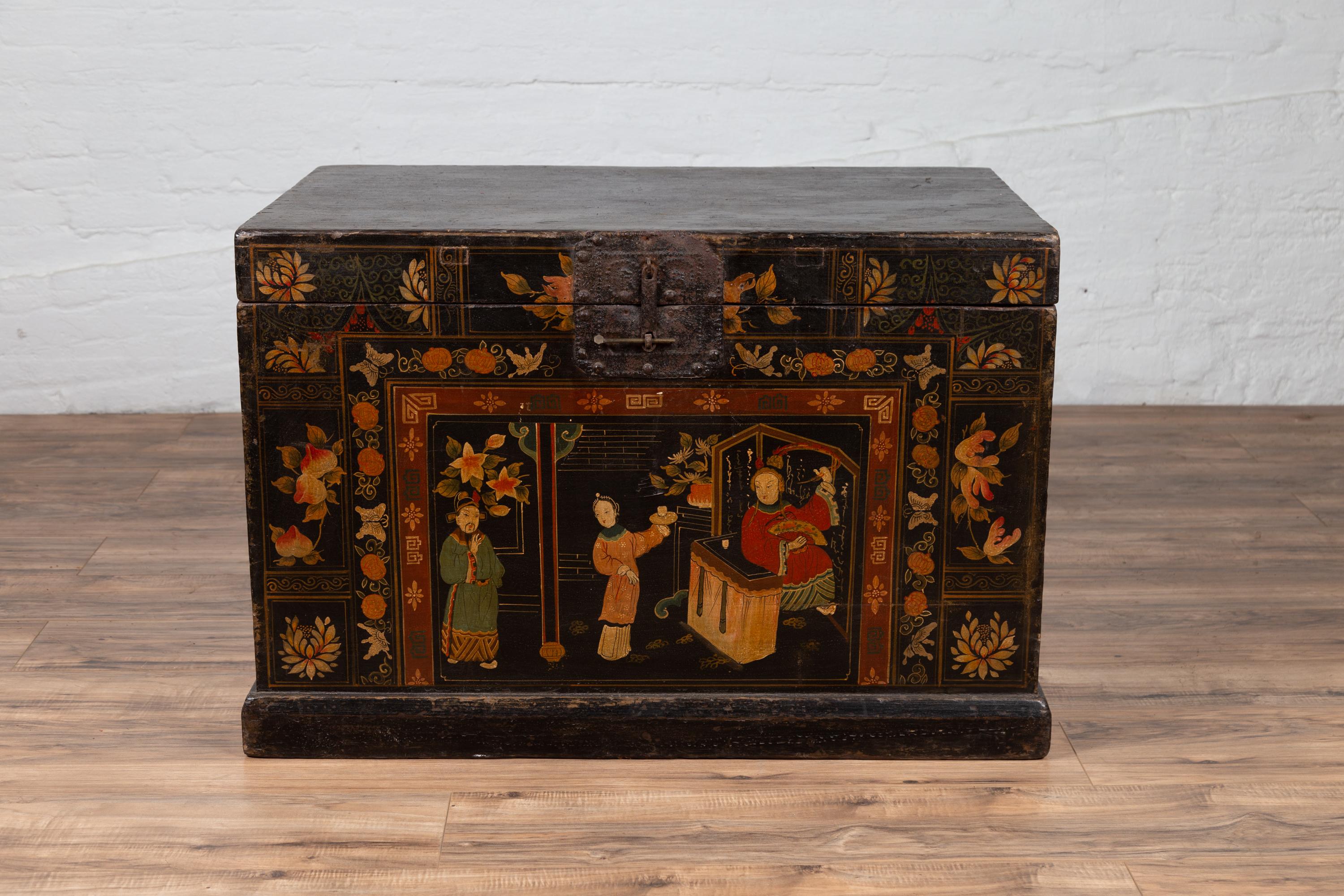 An antique Chinese large decorated black lacquered trunk from the early 20th century, with chinoiserie decor. Born in China during the early years of the 20th century, this trunk features an exquisite and colorful chinoiserie decor depicting court
