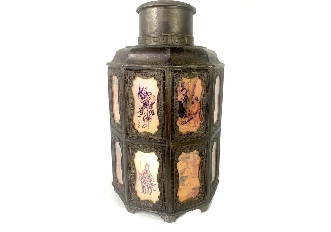 Antico porta tè cinese a 9 lati in piombo e bronzo con 18 pannelli dipinti a mano (dietro vetro) con cornici ornate. Marchio di sigillo in rilievo sulla base. Il porta tè è dotato di un coperchio a cupola rimovibile e poggia su 9 piedini. Circa
