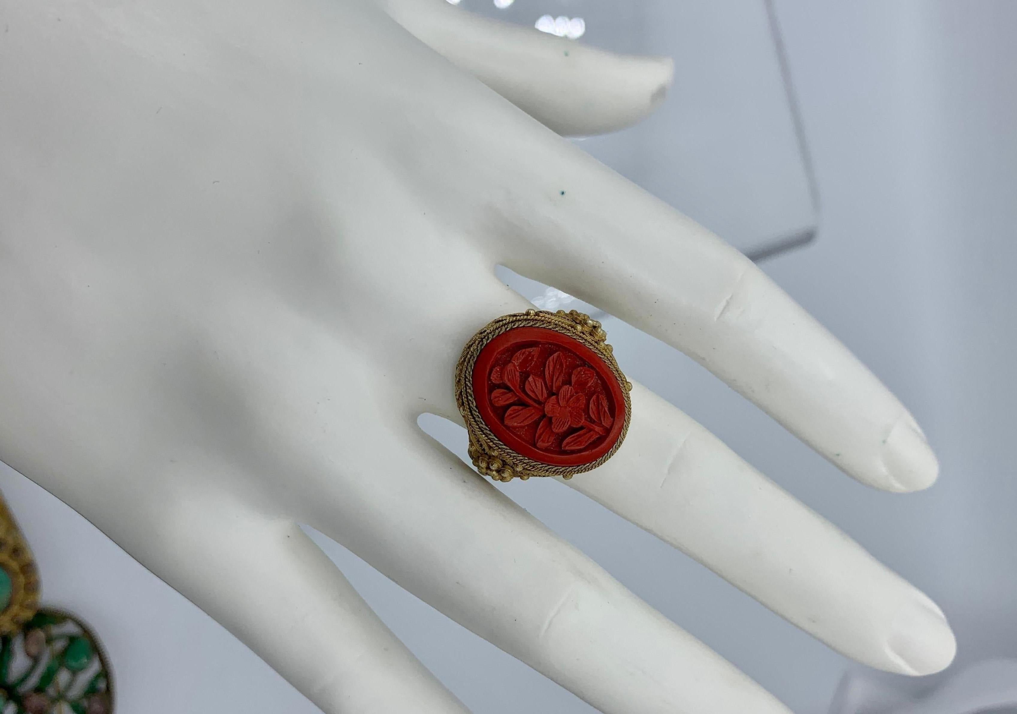 This is a stunning antique Chinese Cinnabar Ring with a central carved Lotus flower motif.  The silver gilt setting is an ornate filigree design.  The Lotus Flower carving of the antique Cinnabar is just gorgeous.  The setting has beautiful open