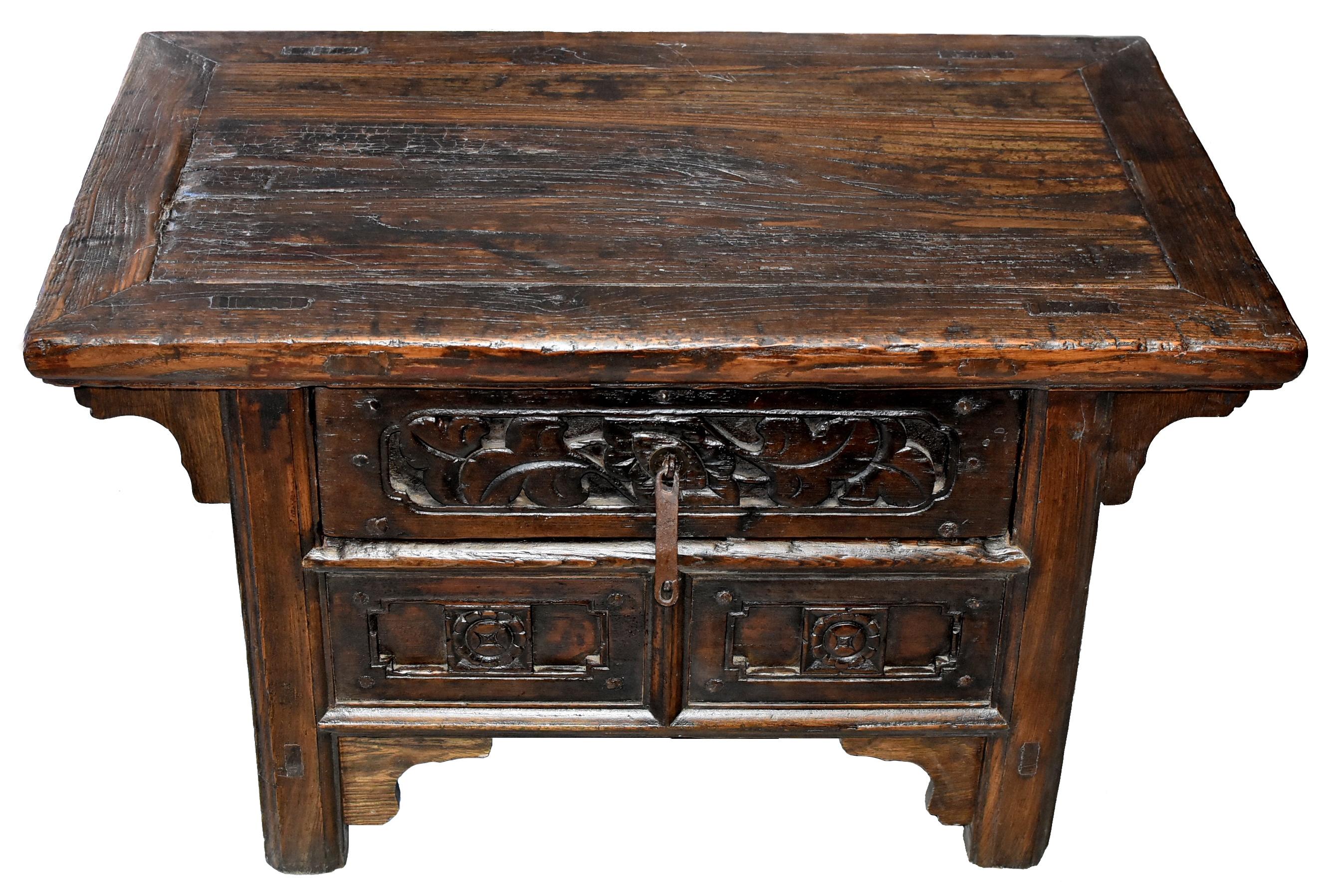 A beautiful rustic low table from Northern China. Its thick solid top has wonderful naturally aged patina. Front of the table is carved with typical Northern Chinese flower and geometric patterns. A large drawer provides ample storage. This is a